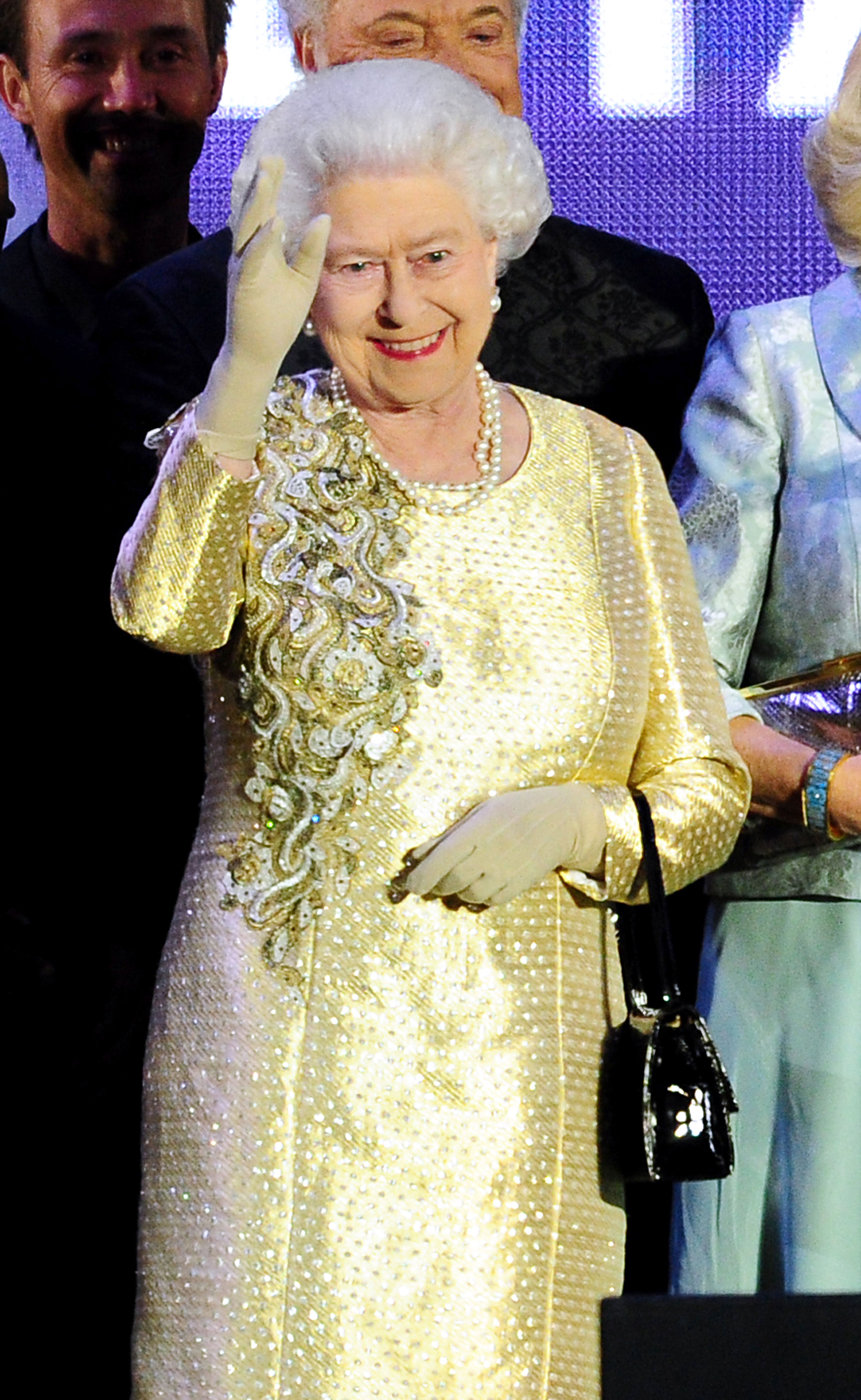 The Queen waves to the crowd while on stage outside Buckingham Palace during the Diamond Jubilee Concert (Ian West/PA)