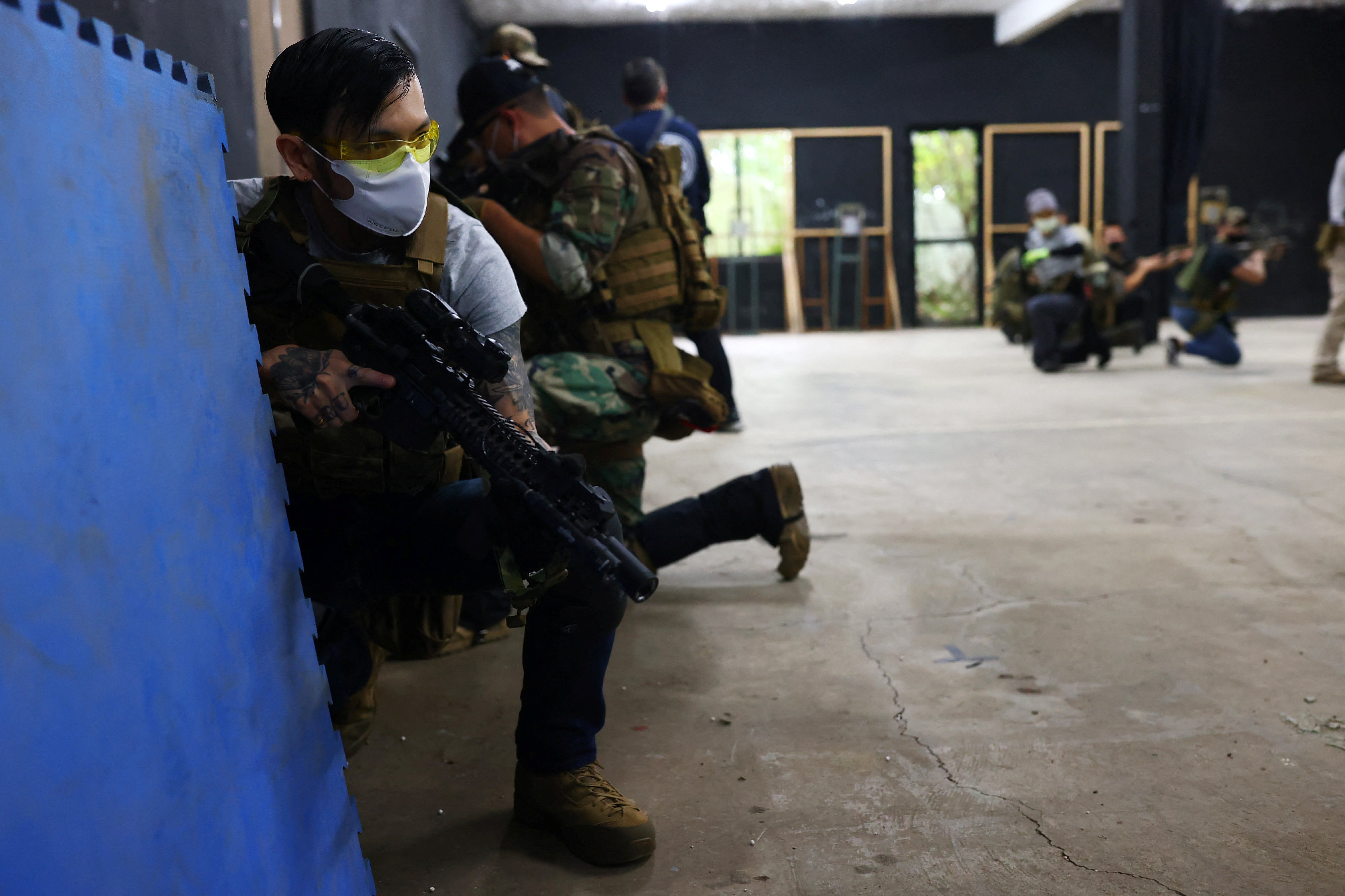 Tattoo artist Su Chun holds an airsoft gun at the shooting range