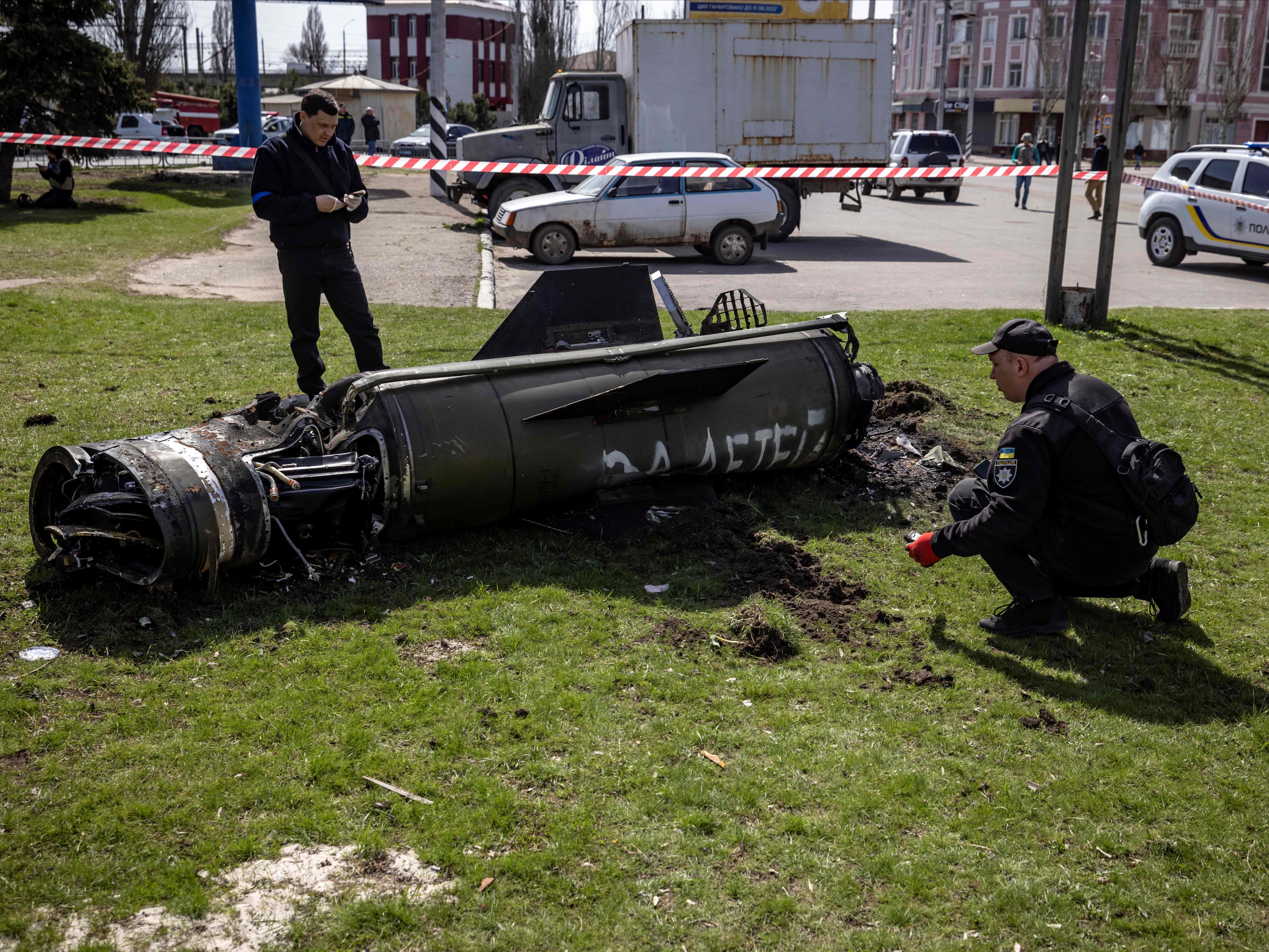 Ukrainian police inspect the remains of a large rocket with the words ‘for the children’ in Russian next to the main building of a train station in Kramatorsk