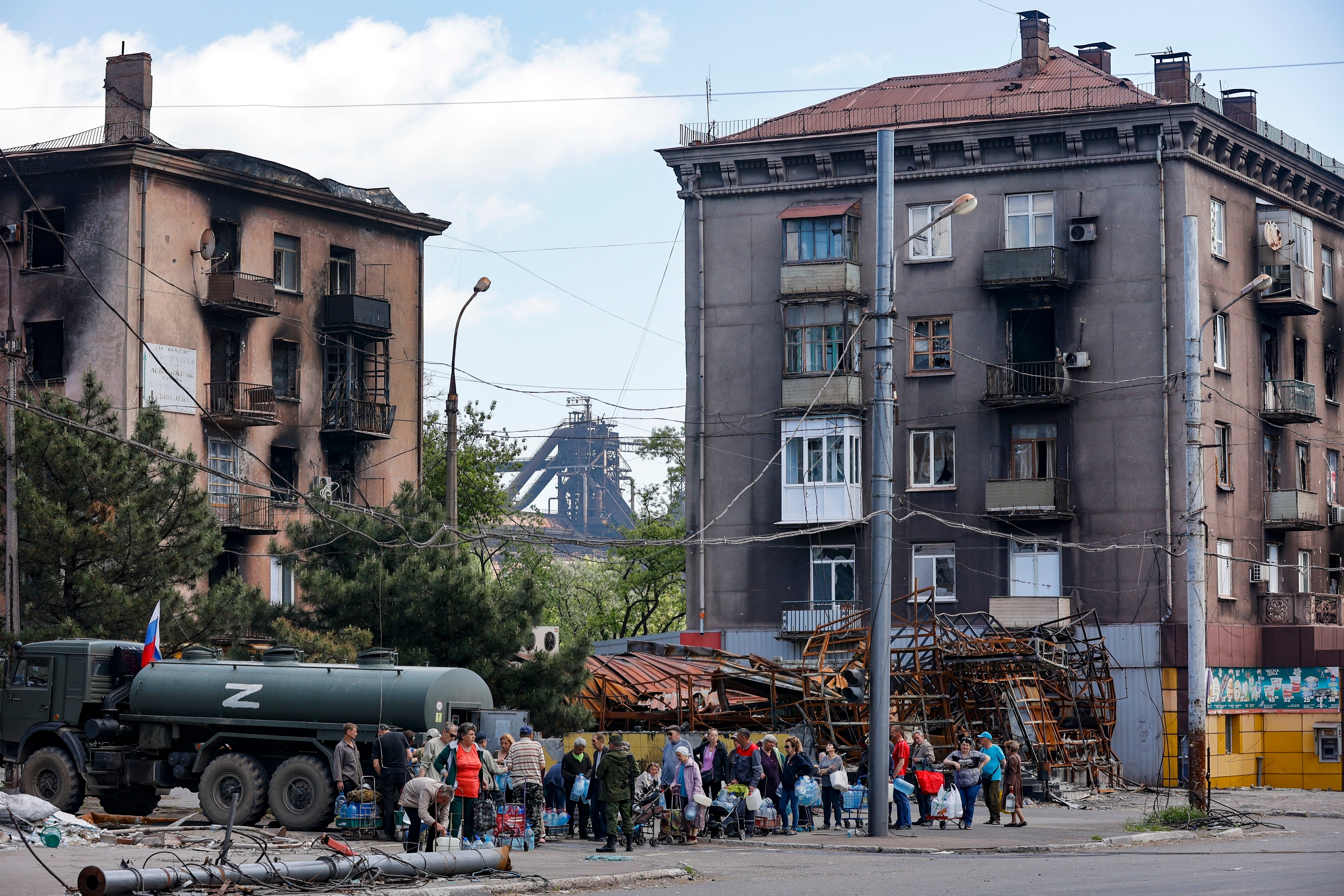 Local civilians gather to receive pure water distributed by the Russian emergency situations ministry in Mariupol