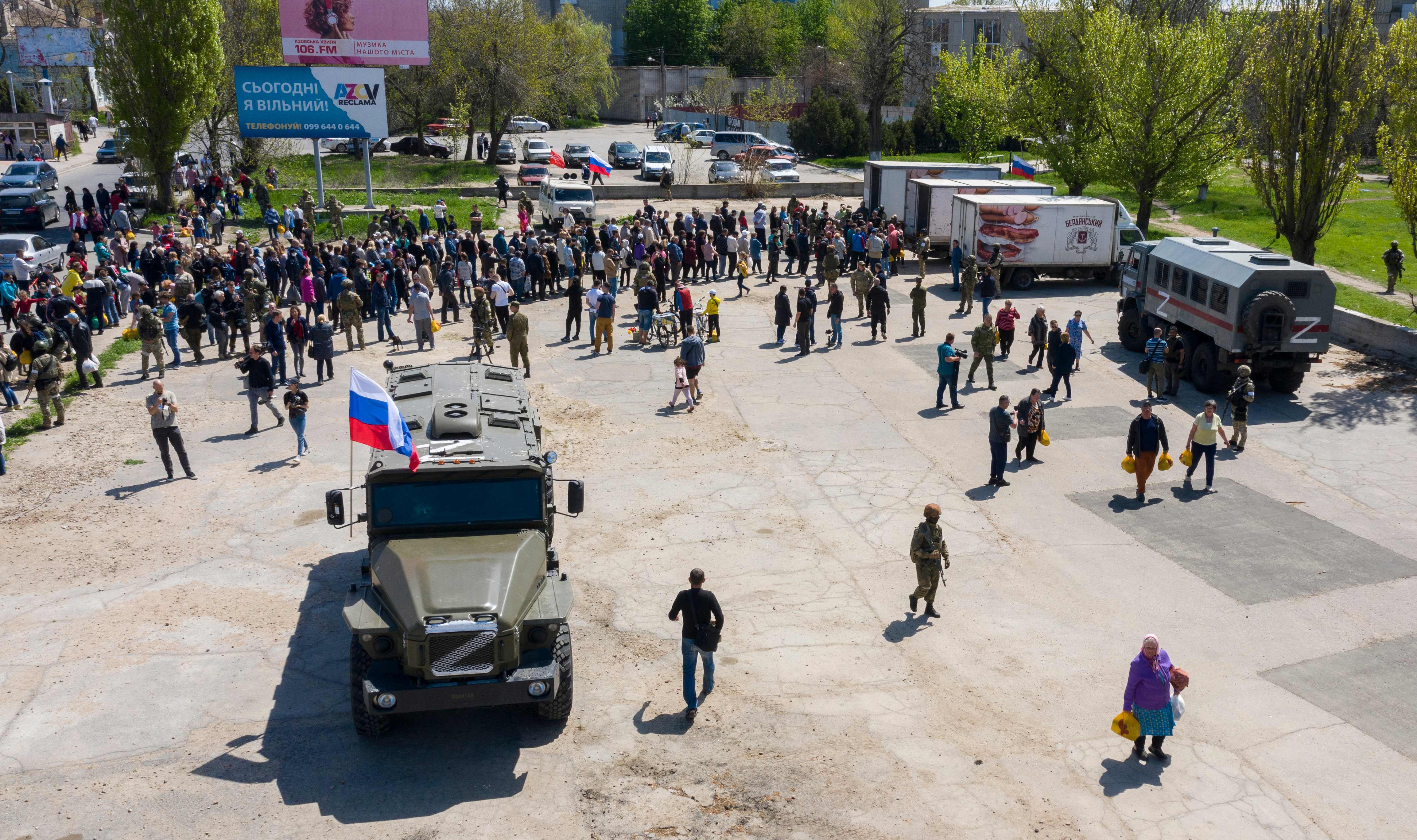 Local people and refugees from Donetsk region line up for humanitarian aid distributed from Russian military trucks in Berdyansk