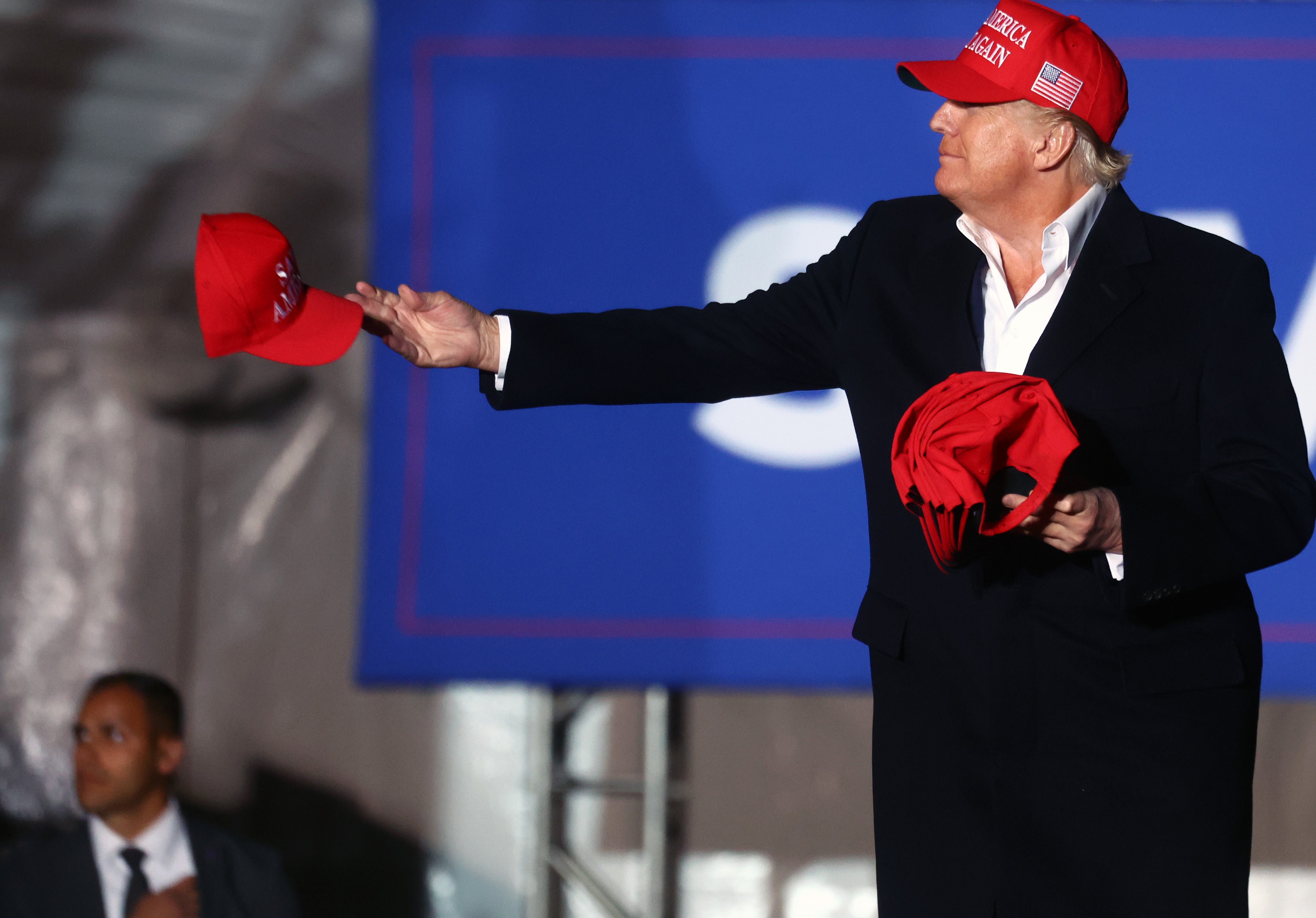 Trump, pictured in 2022, hands out red MAGA hats – a common gift he offers to supporters at rallies or smaller events