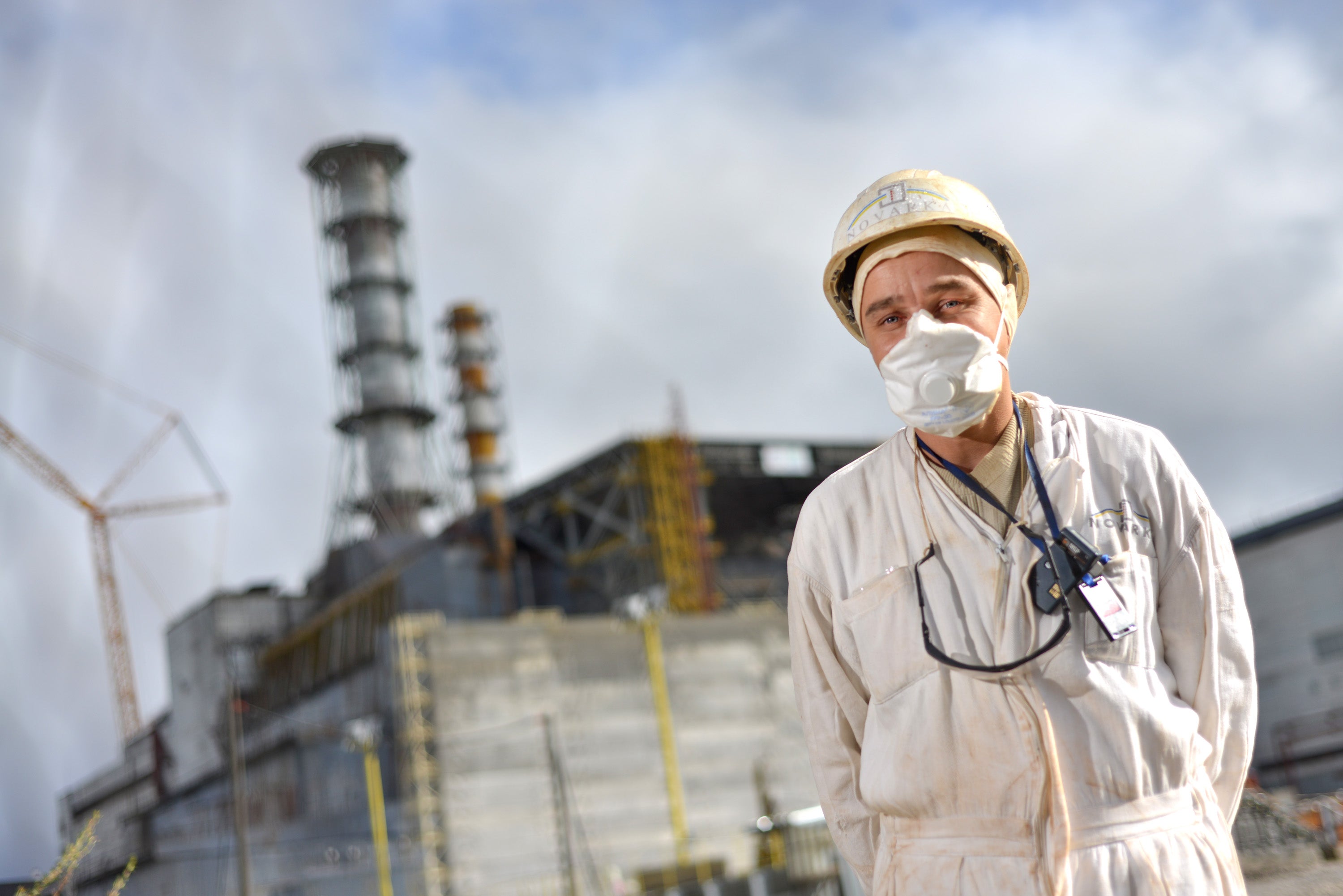 A worker in front of the sarcophagus encasing one of the reactors prior to the invasion