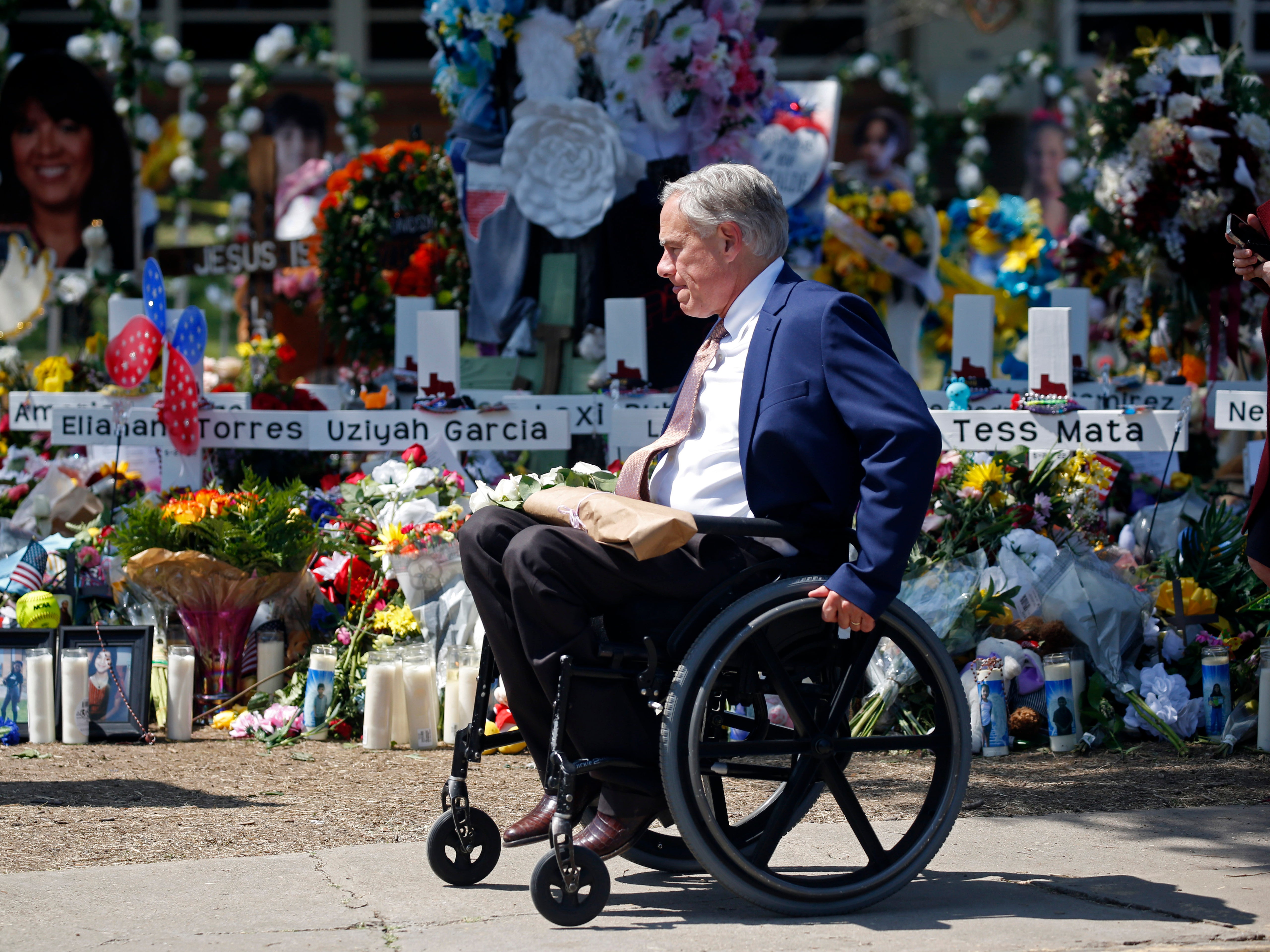 Texas Governor Greg Abbott passes in front of a memorial outside Robb Elementary School to honor the victims killed in this week's school shooting in Uvalde, Texas, Sunday, May 29, 2022