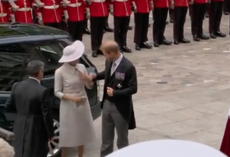 Prince Harry helps Meghan Markle straighten her dress collar at platinum jubilee celebration