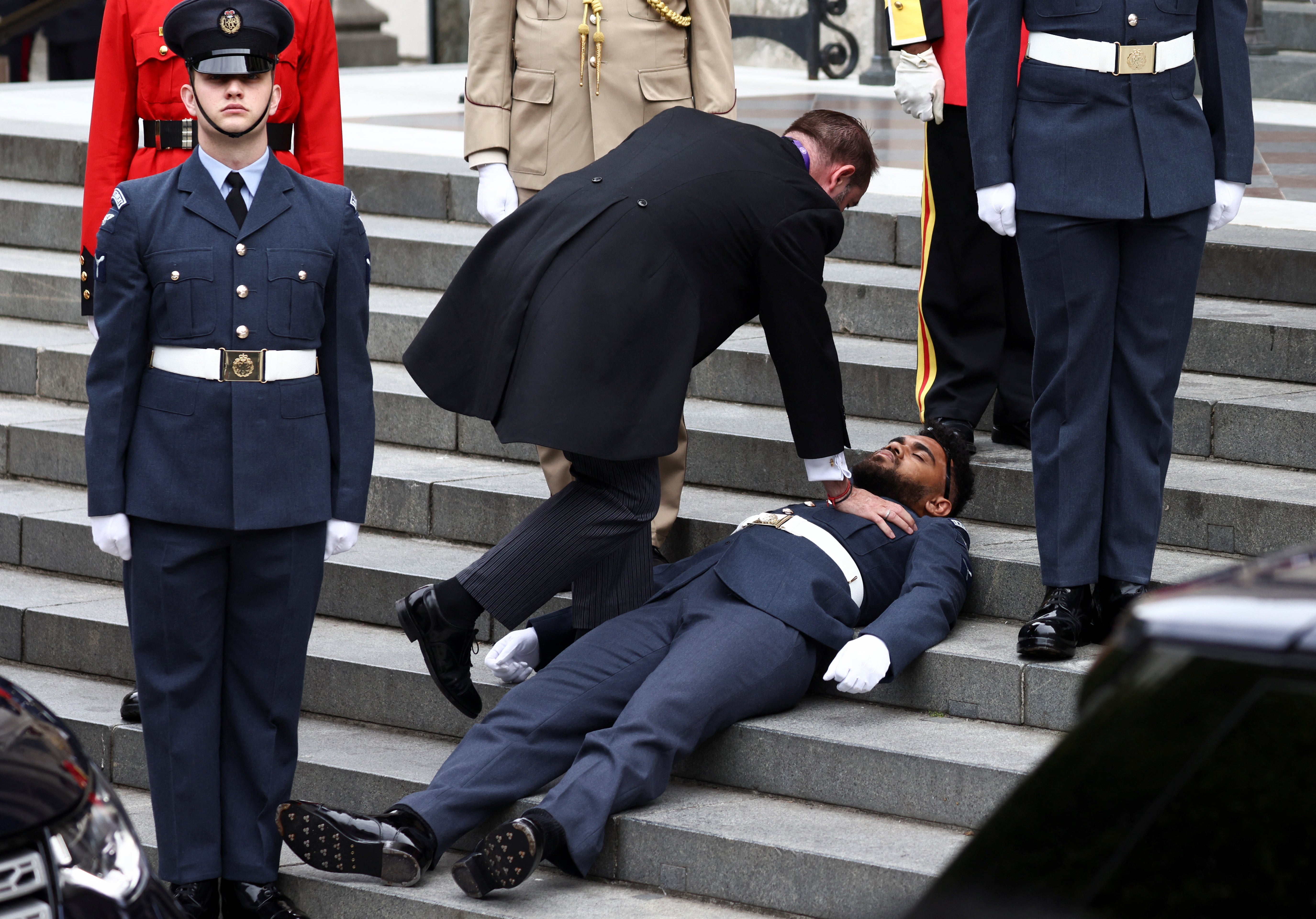 Another guardsman also fainted and had to be helped away (Henry Nicholls/PA)