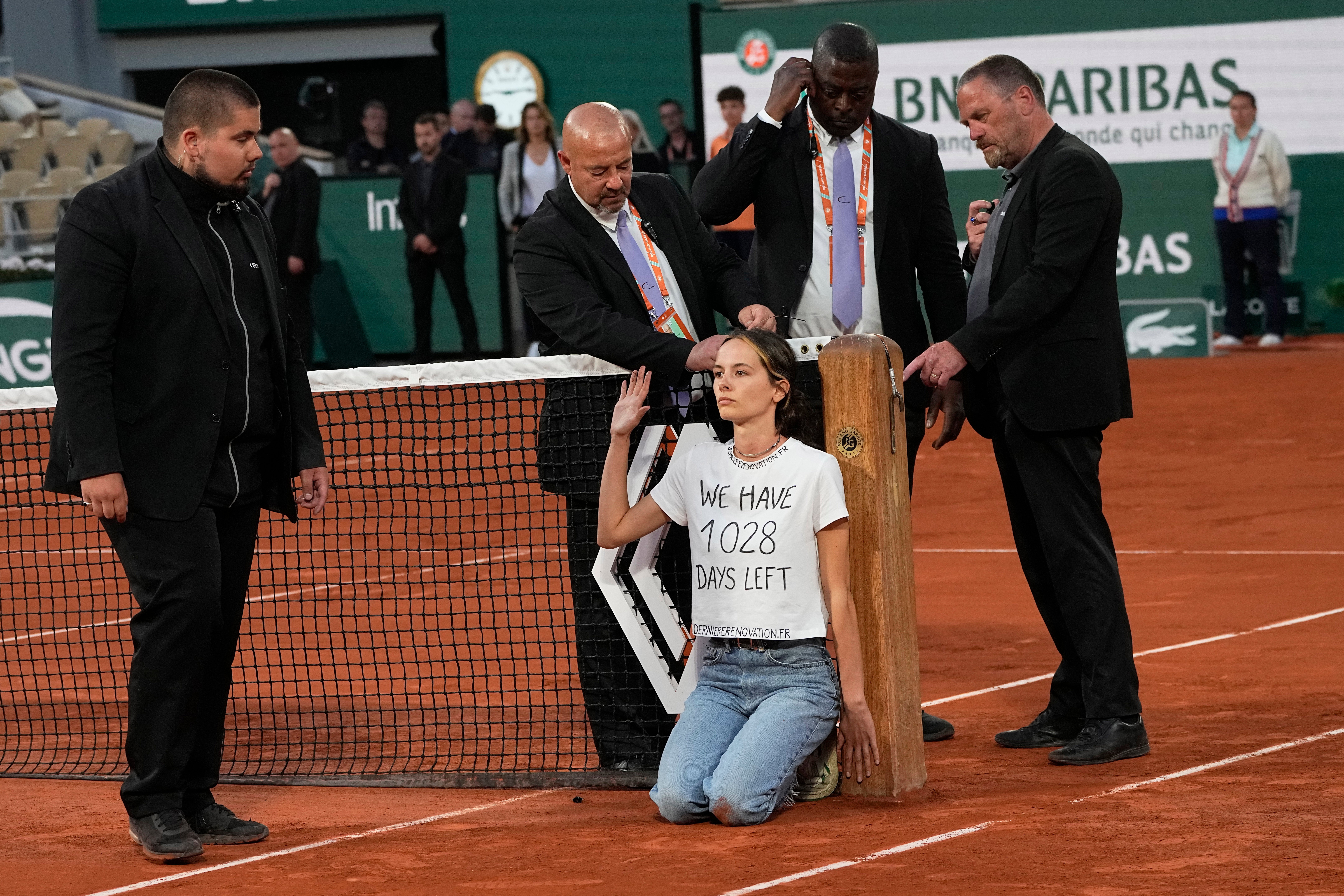 A woman invaded the court and chained herself to the net during the Ruud/Cilic semi-final (Michel Euler/AP)