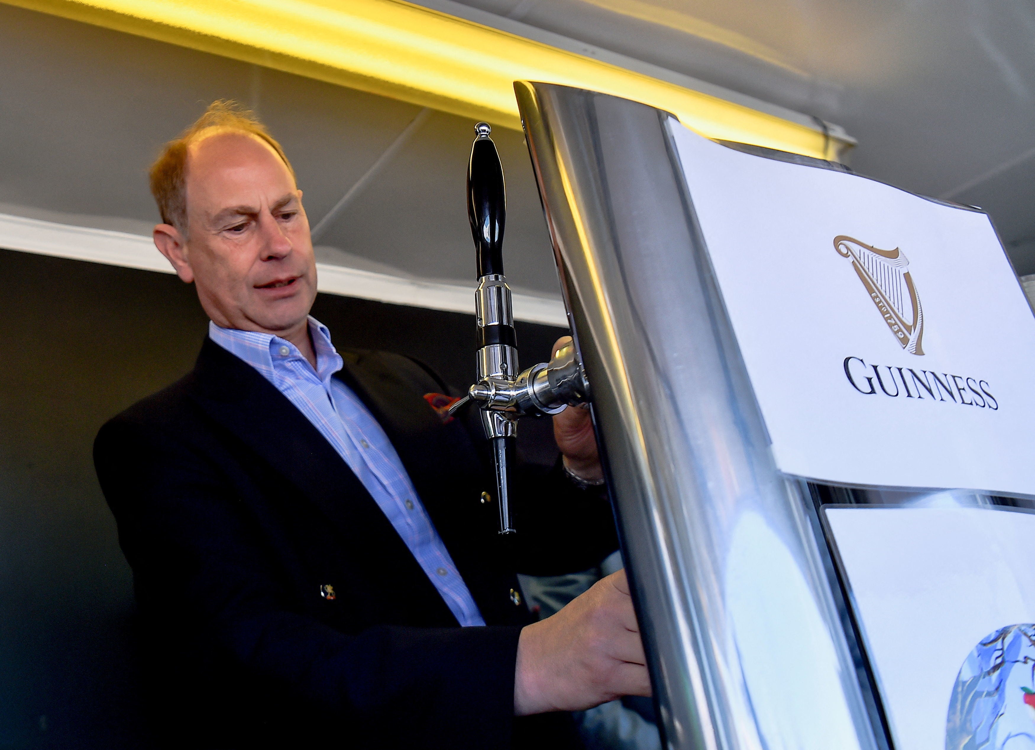 The Earl Wessex pours a pint of Guinness during a visit to Bangor, Northern Ireland