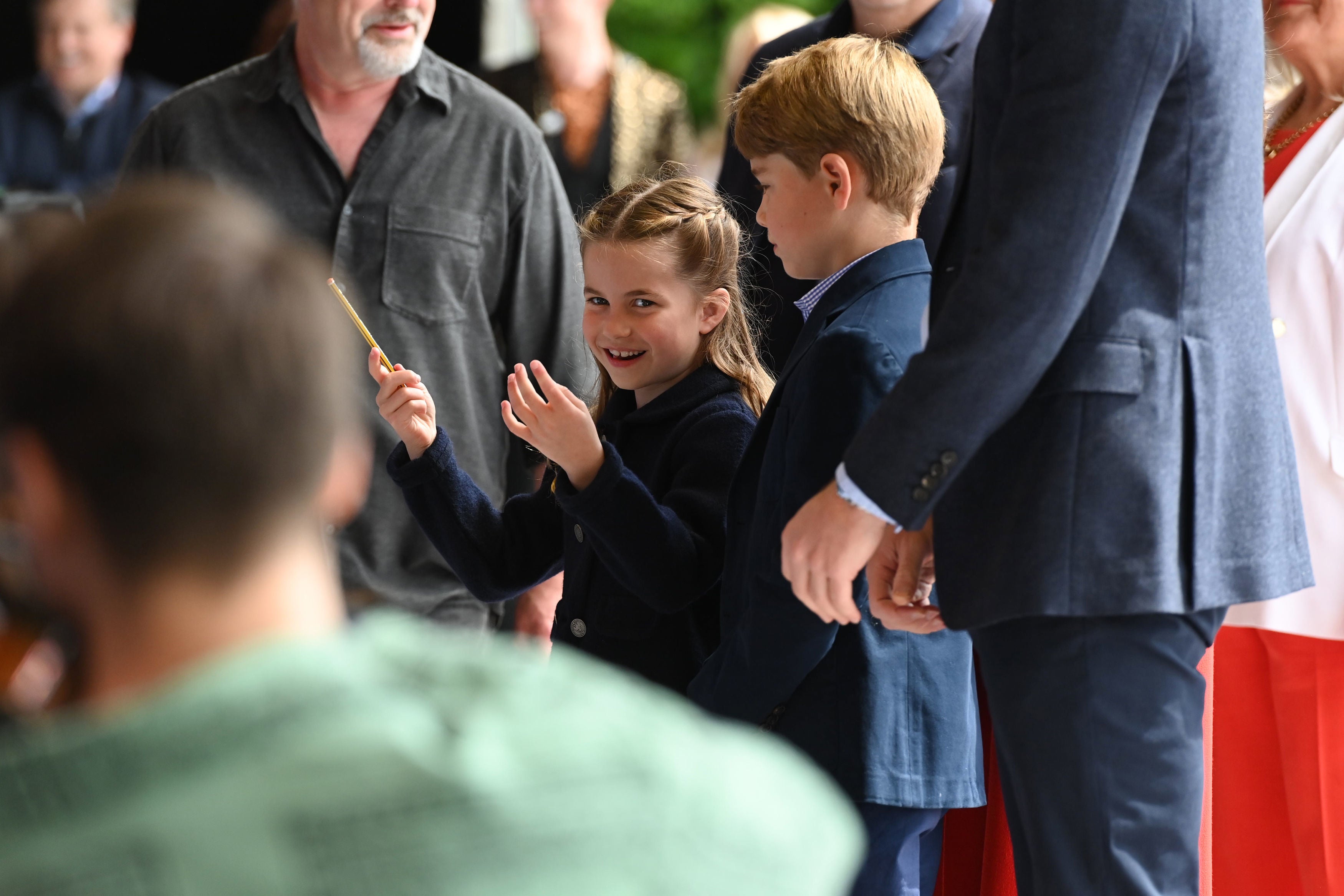 Princess Charlotte laughs as she conducts a band next to her brother, Prince George, during their visit to Cardiff Castle to meet performers and crew involved in the special Platinum Jubilee Celebration Concert