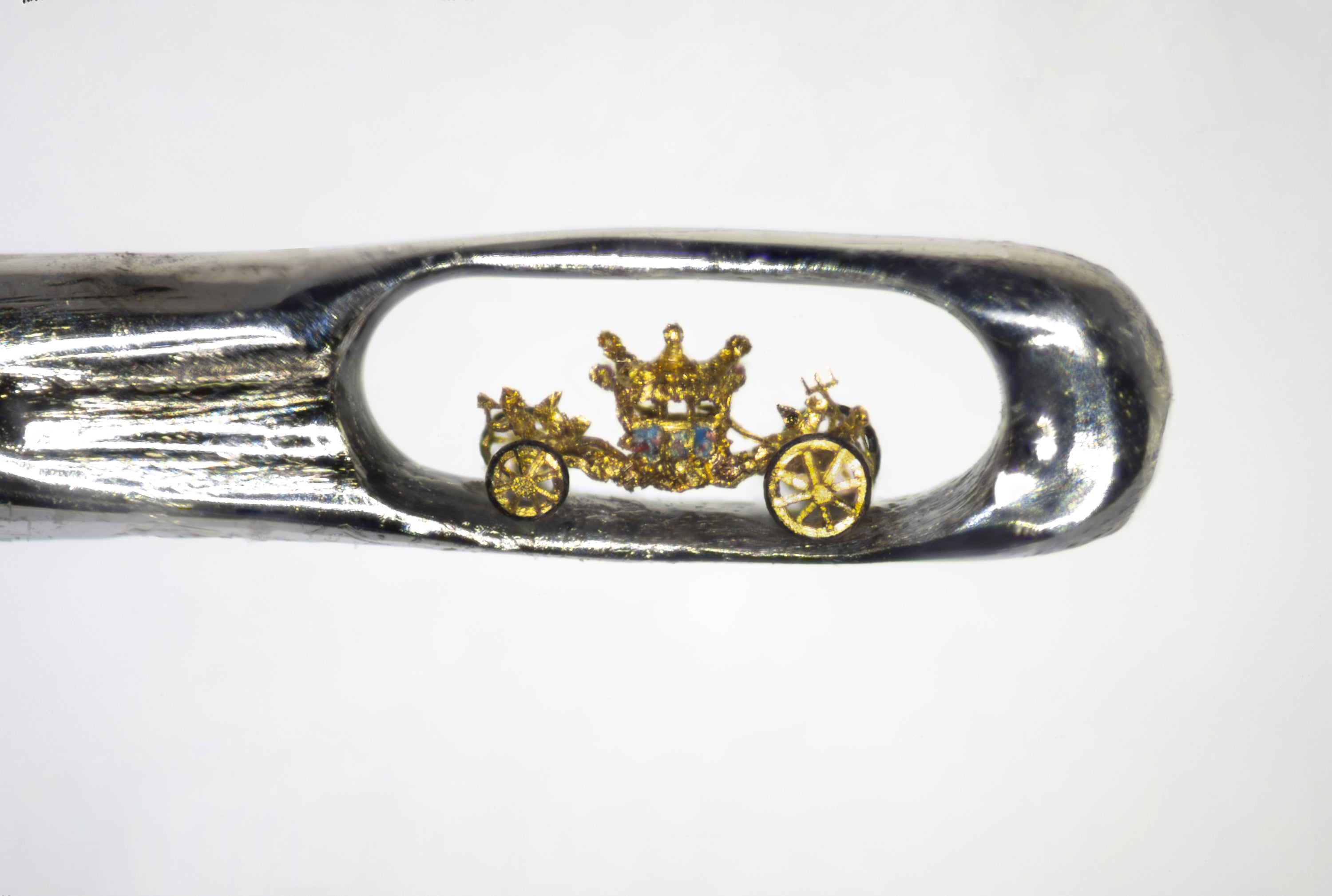 Dr Willard Wigan’s tiny model of the Queen’s Coronation Carriage fits inside the eye of a needle (Darren Shipman/Dr Willard Wigan/PA)