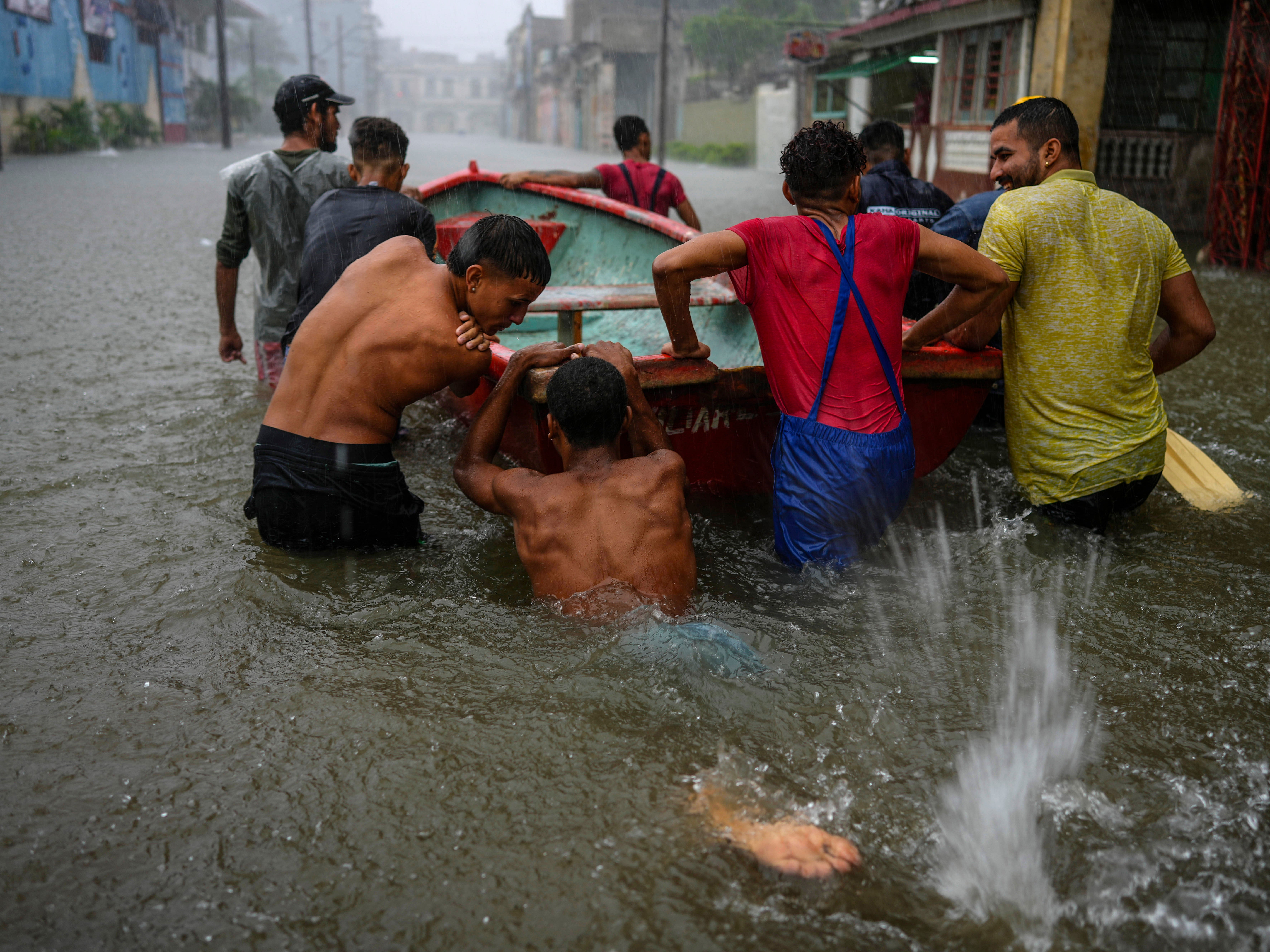 Volunteers push a boat through a flooded street to rescue a neighbour who cannot leave his home in Havana, Cuba, 3 June 2022