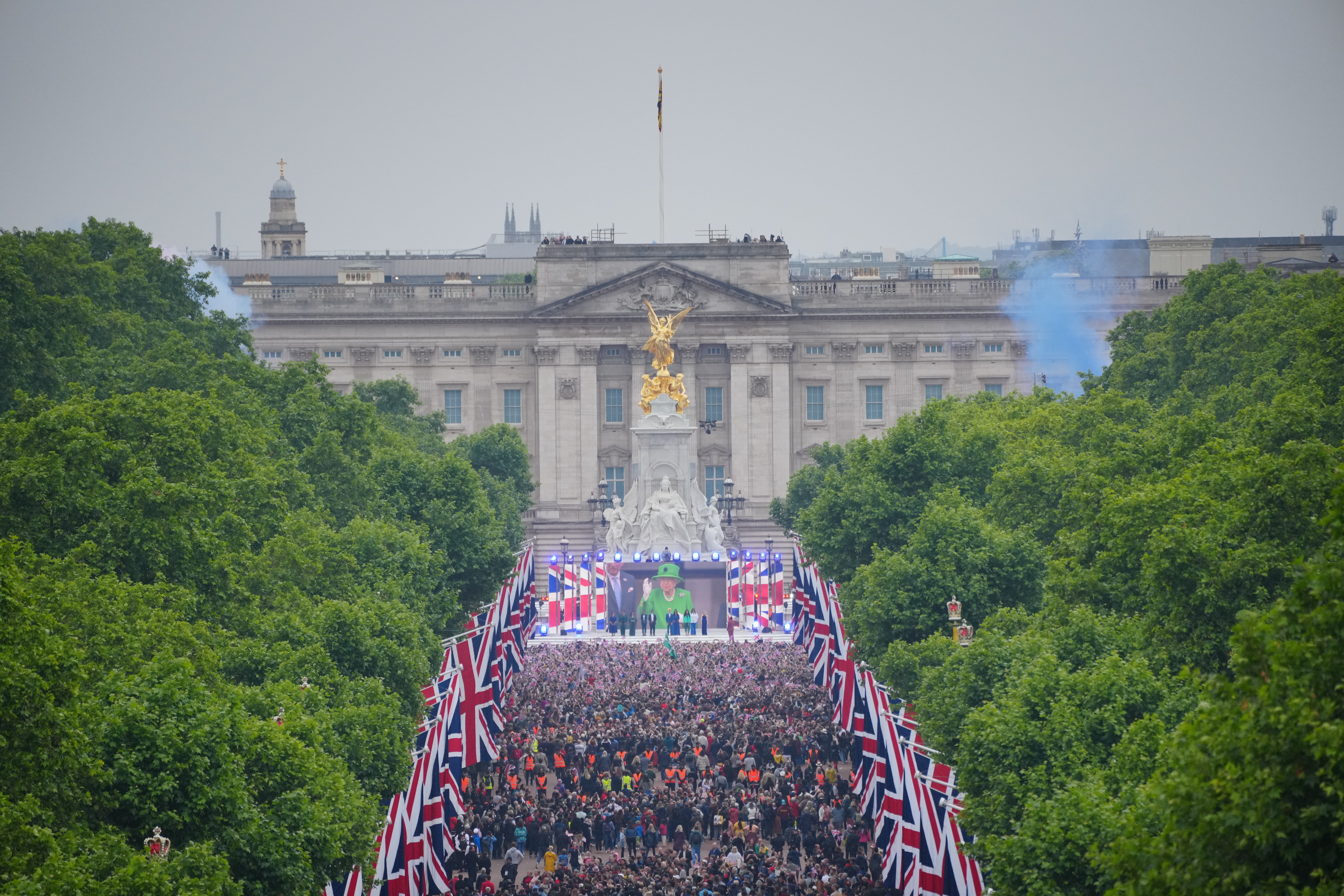 Crowds are seen on The Mall with Queen Elizabeth II shown on a screen during the singing of the National Anthem at the Platinum Jubilee Pageant in front of Buckingham Palace, London, on day four of the Platinum Jubilee celebrations. Picture date: Sunday June 5, 2022.