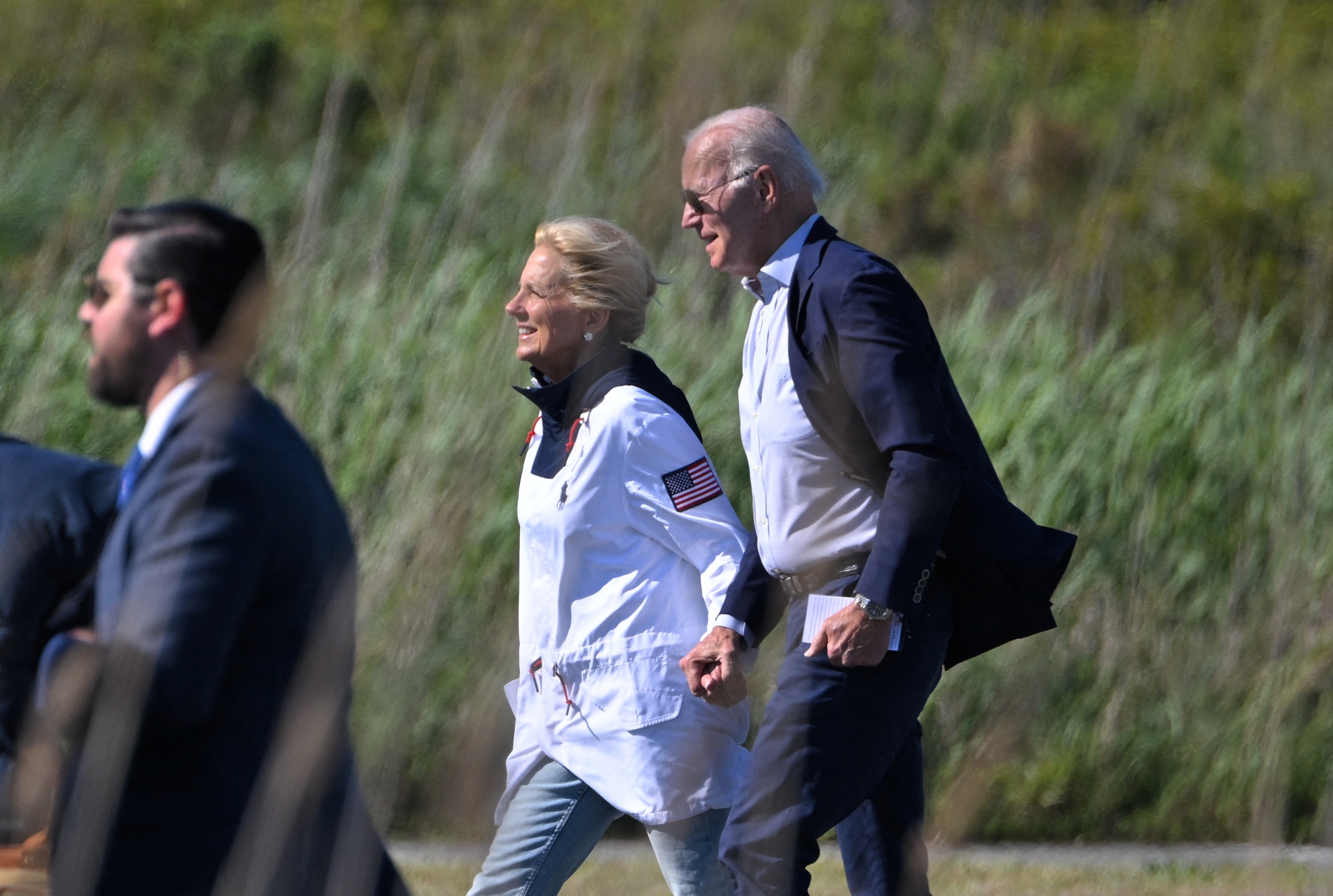 US president Joe Biden and US first lady Jill Biden make their way to board Marine One before departing from Gordons Pond in Cape Henlopen State Park in Rehoboth Beach, Delaware