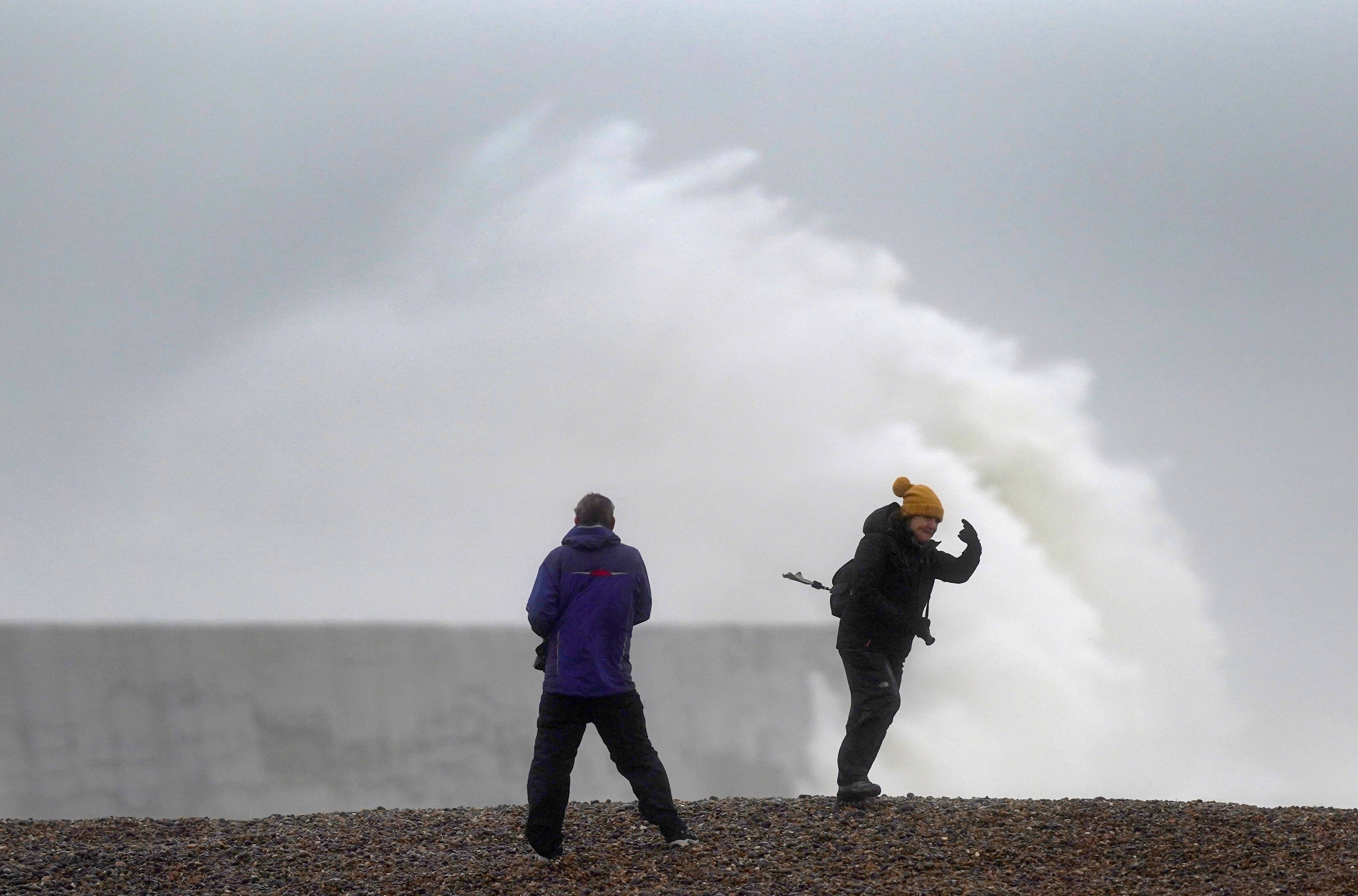 A wave crashes over the sea wall at West Quay in East Sussex (Steve Parsons/PA)