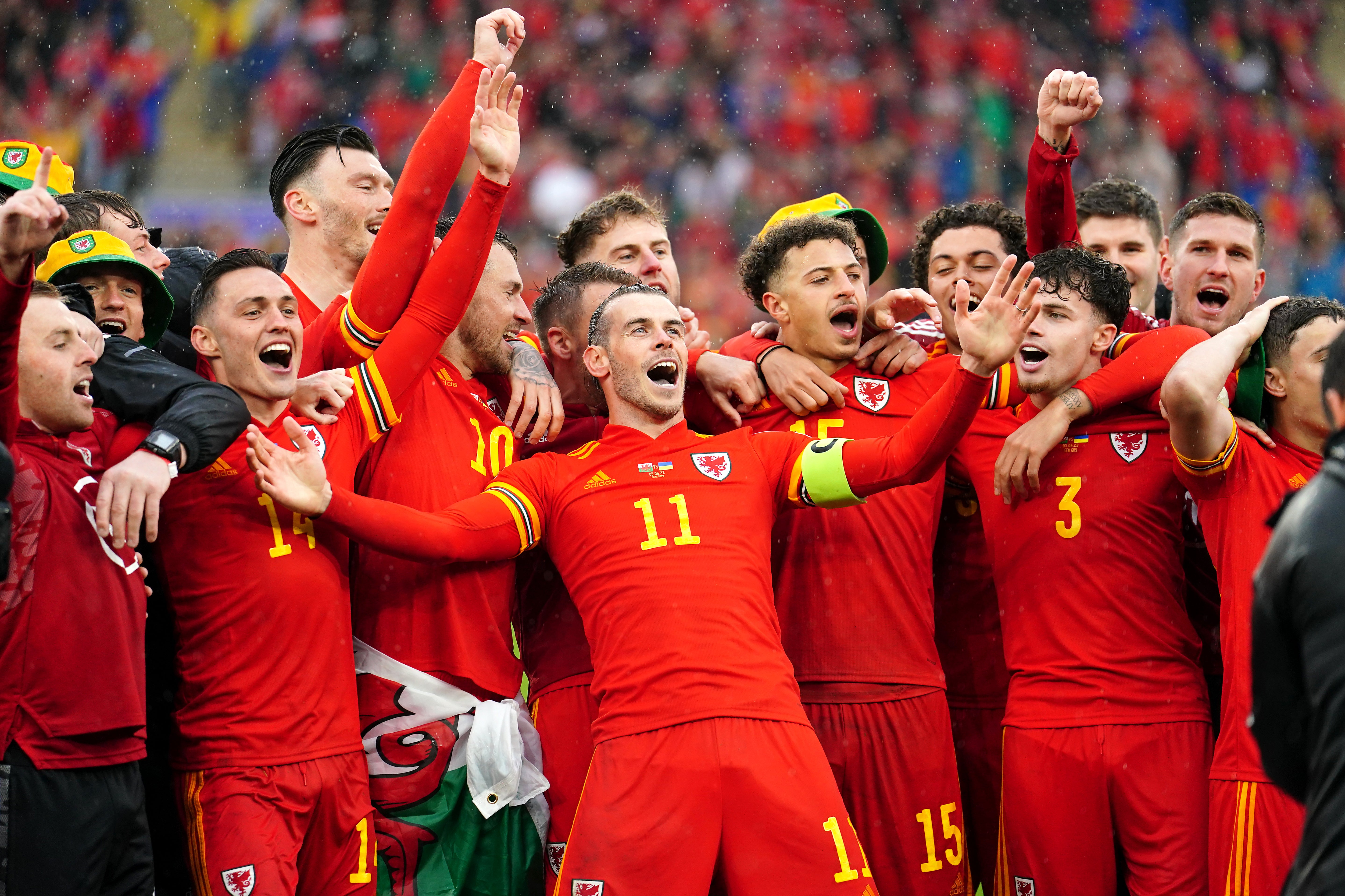 Gareth Bale (centre) celebrates with team-mates and staff after qualifying for the Qatar World Cup (David Davies/PA)