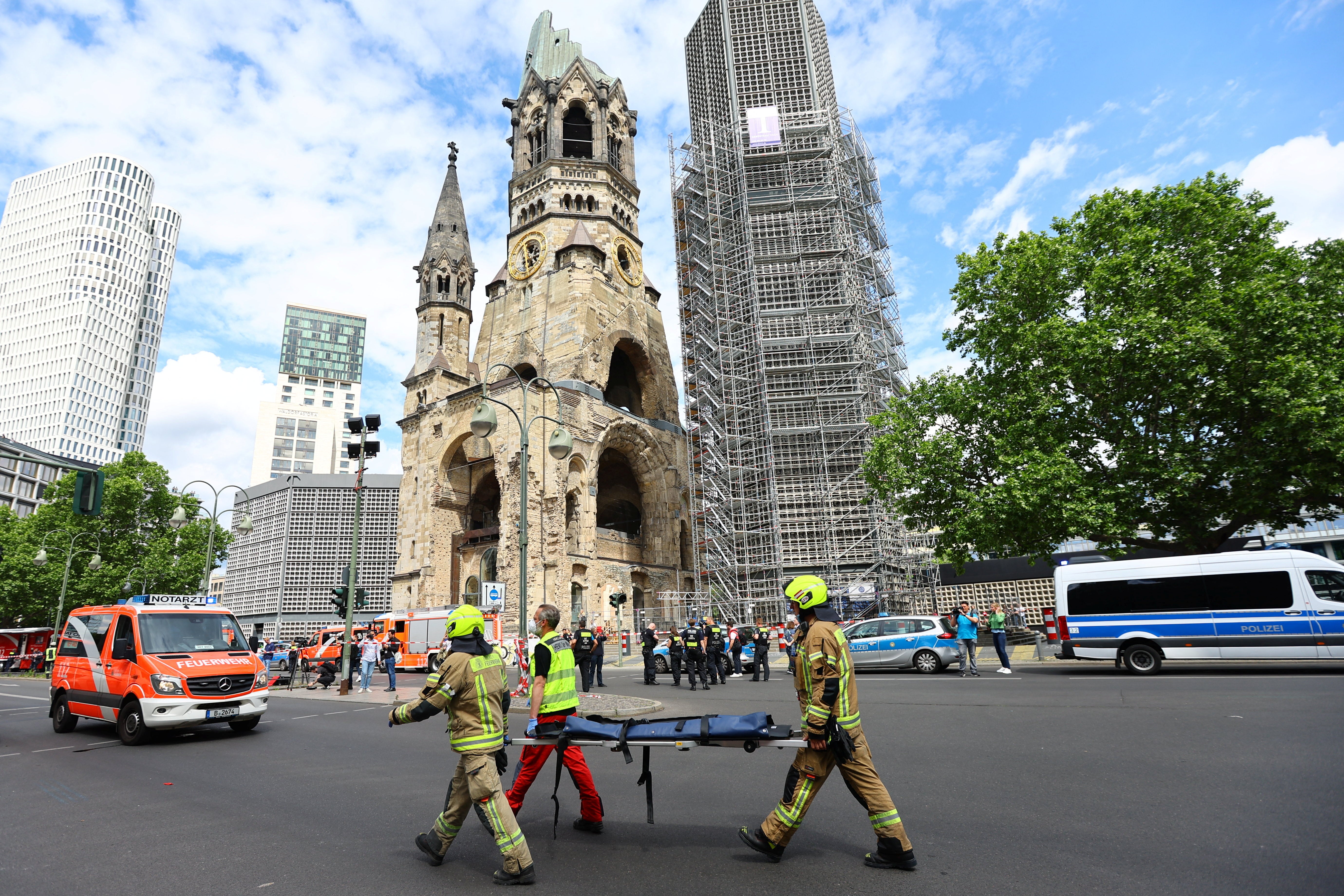 Emergency crews work at the site after a car crashed into a group of people, injuring dozens and killing at least on