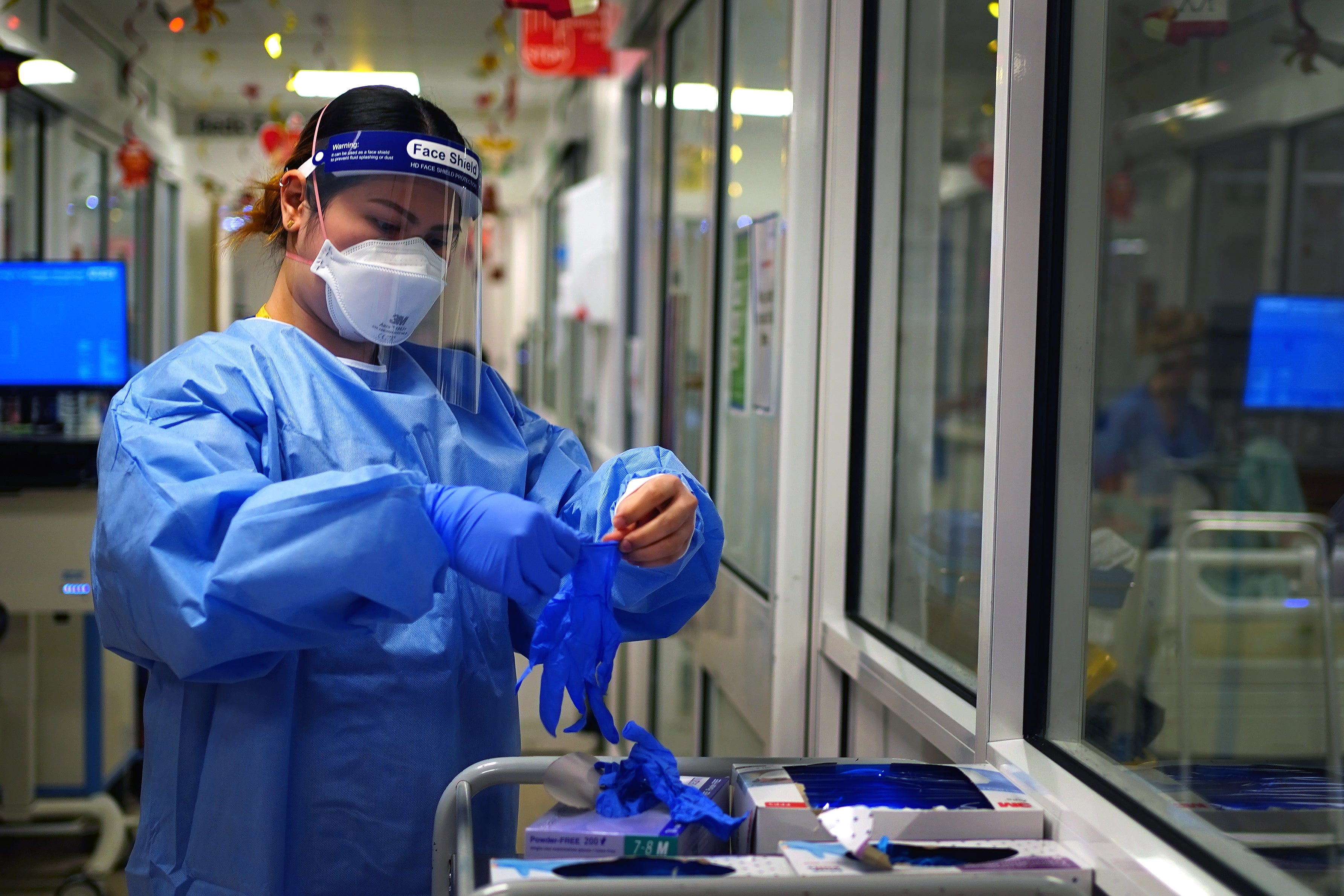 File. A nurse puts on PPE in a ward for Covid patients at King’s College Hospital, in southeast London