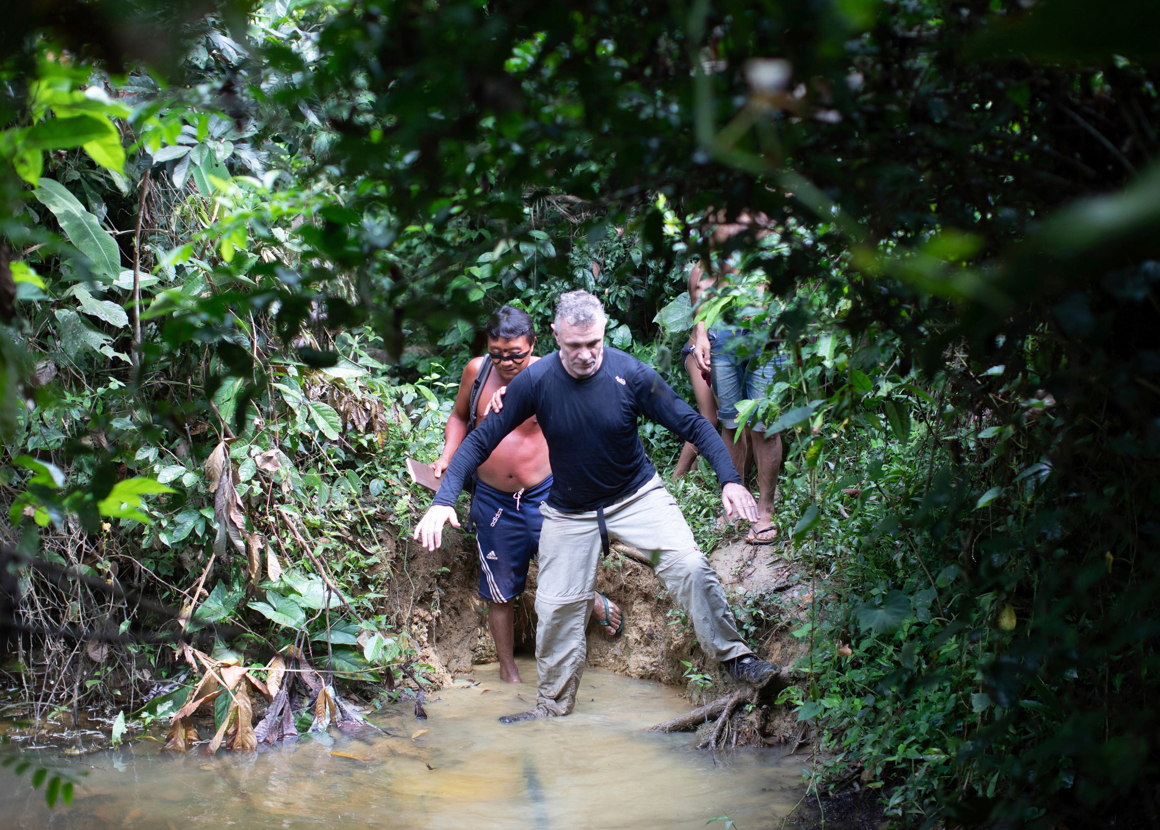 British journalist Dom Phillips, right, and a Yanomami Indigenous man walk in Maloca Papiu village, Roraima state, Brazil in 2019