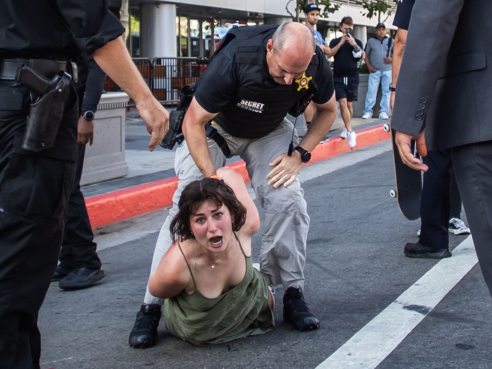 A Secret Service police officer wrestles a protester to the ground after she ran towards a motorcade on its way to the LA Convention Center where North and South American leaders are gathered for the ninth Summit of the Americas in Los Angeles, June 8, 2022