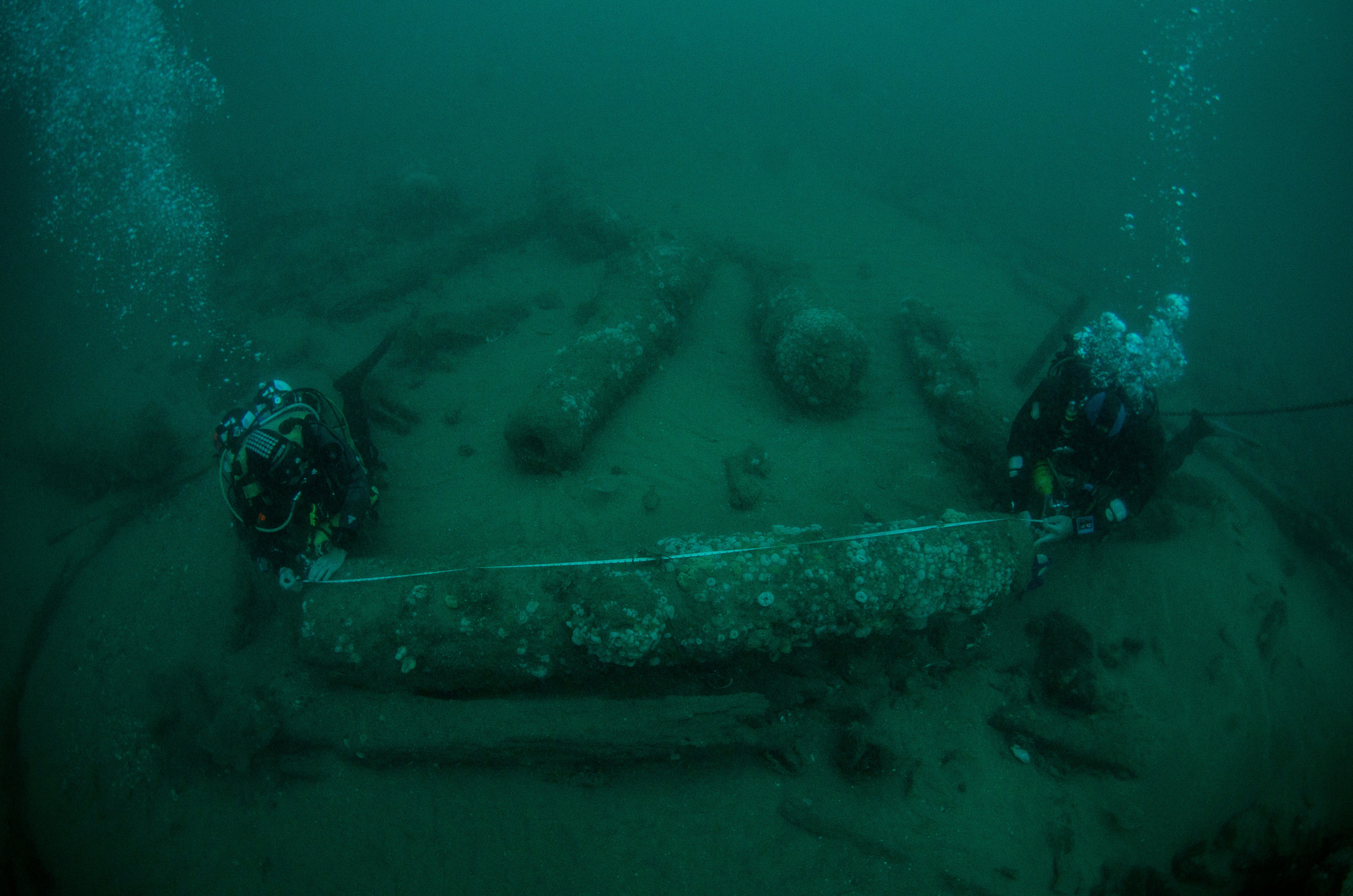 Brothers Julian and Lincoln Barnwell examine a cannon from the wreck of the HMS Gloucester, which they located off the Norfolk coast (Norfolk Historic Shipwrecks/ PA)