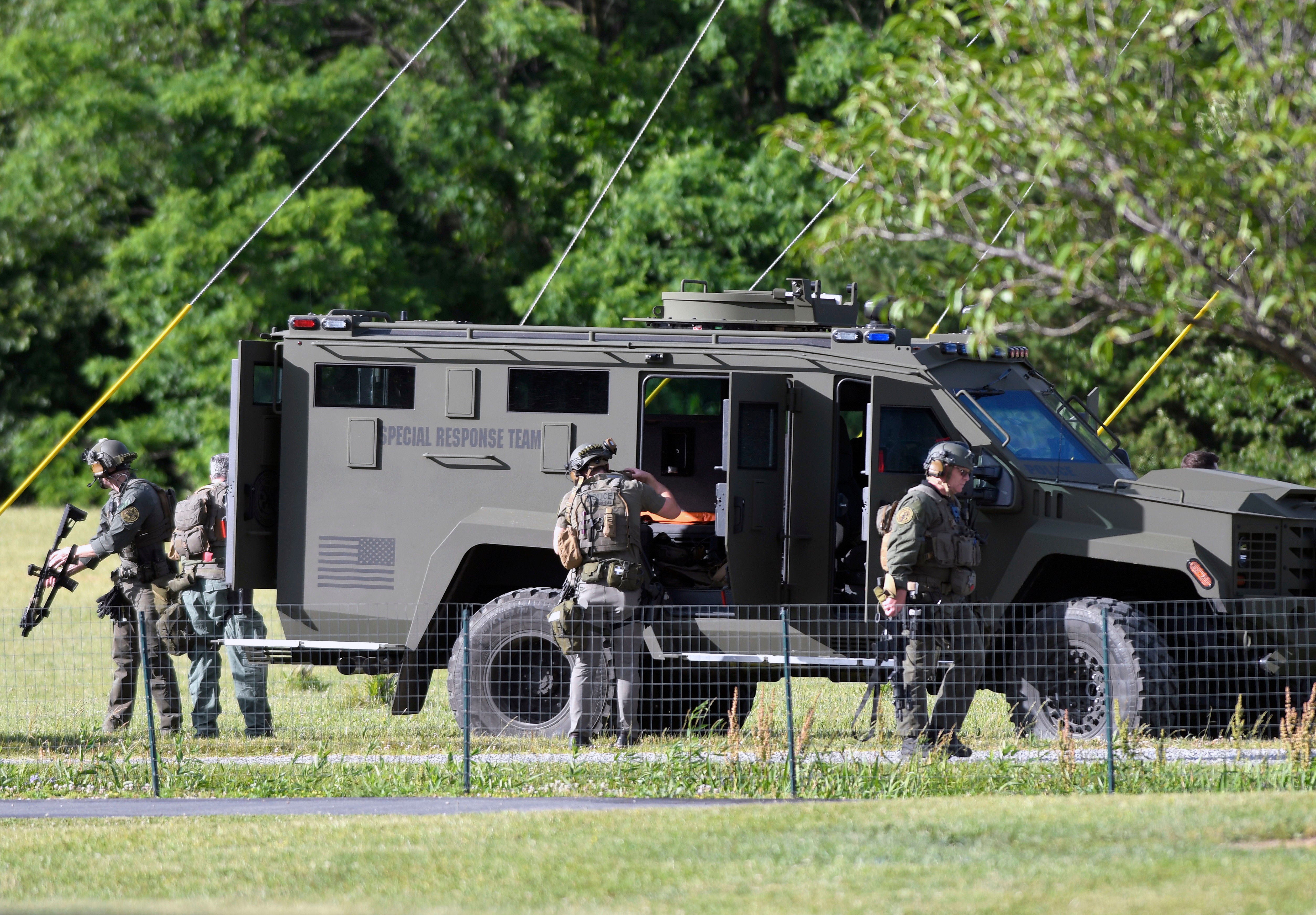 Tactical police work near where a man opened fire at a business, killing three people before the suspect and a state trooper were wounded in a shootout, according to authorities, in Smithsburg, Md., Thursday, June 9, 2022.