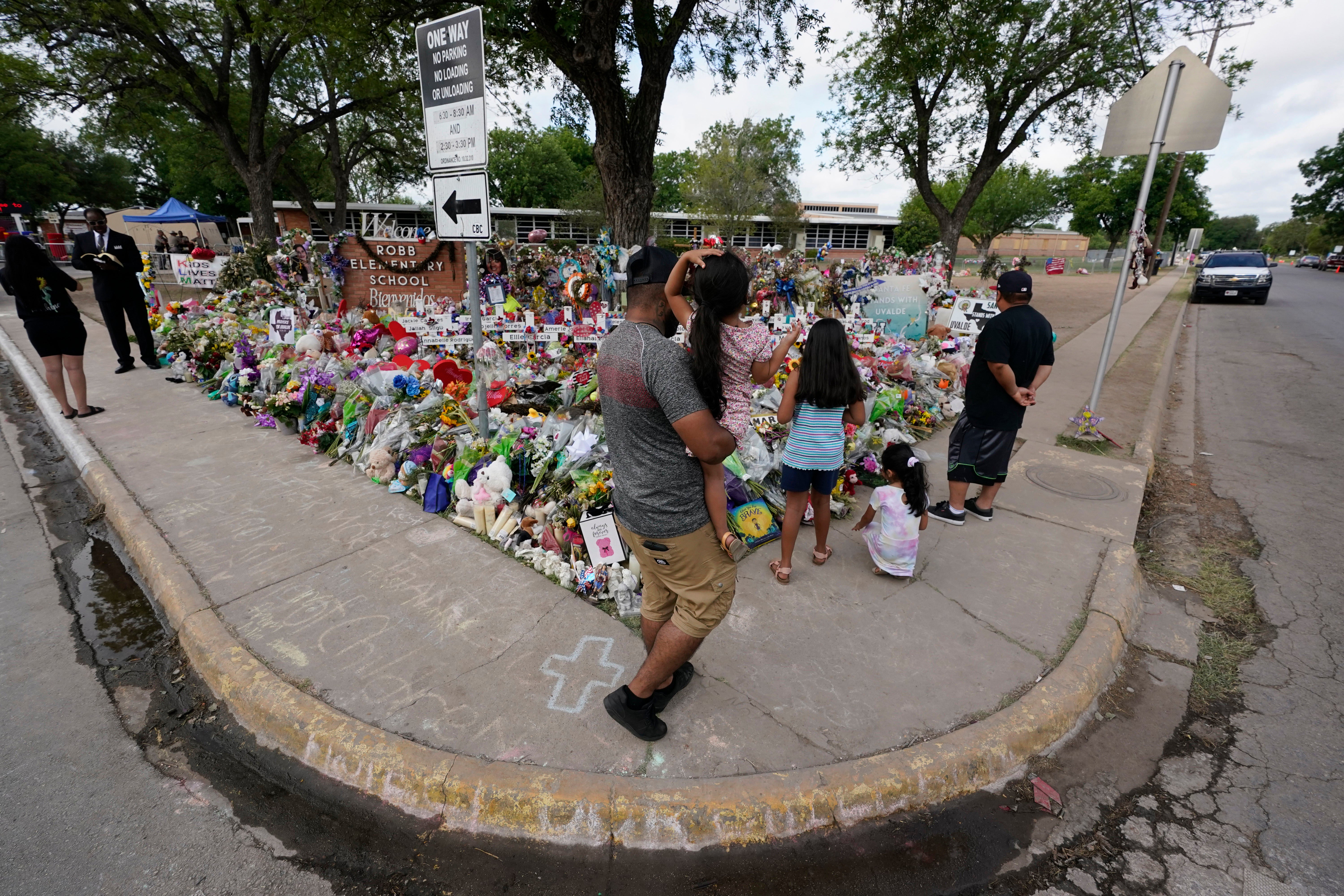 Mourners visit a memorial at Robb Elementary School