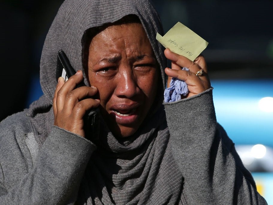 Human cost: a woman weeps as she tries to trace a missing relative in Grenfell