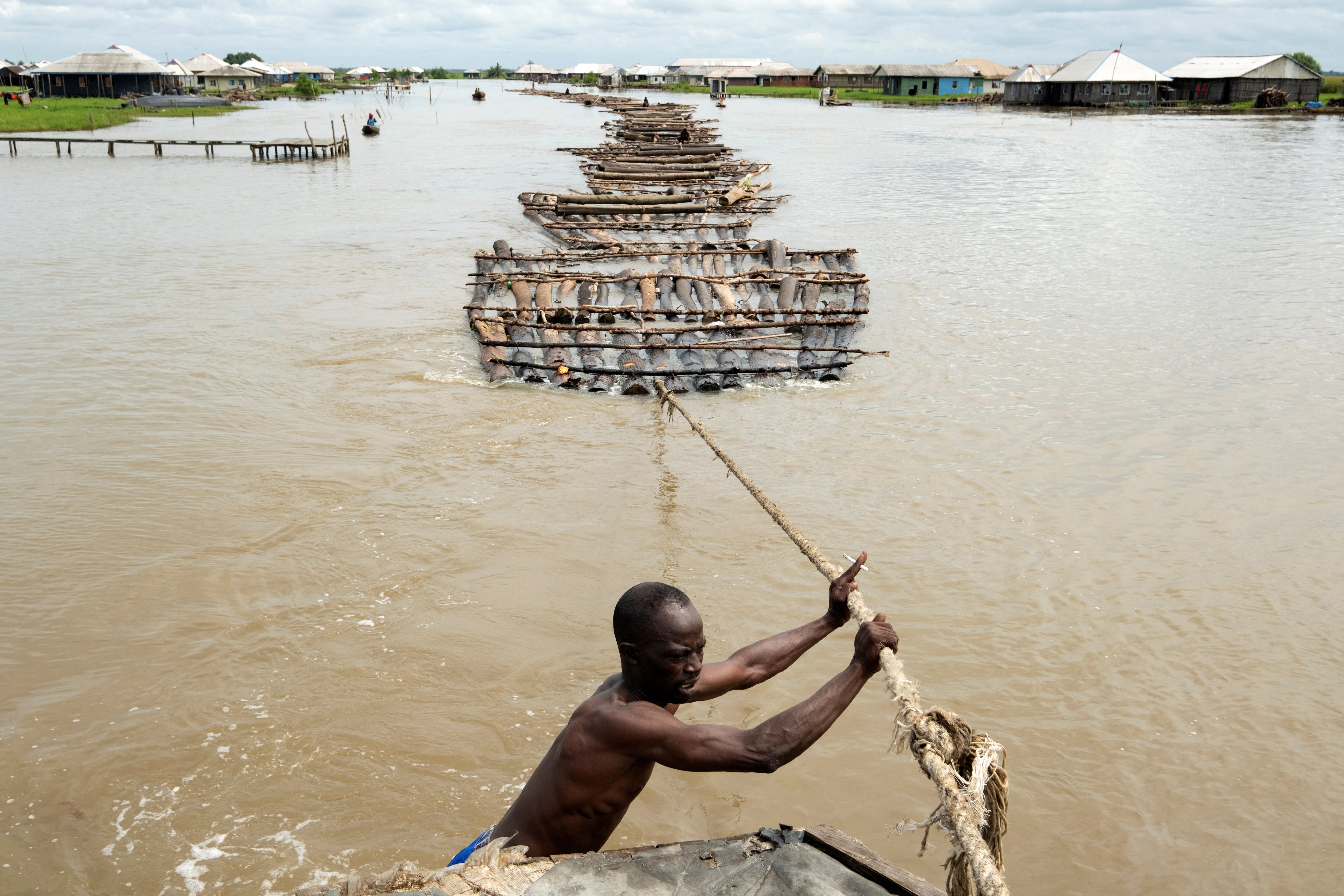 Elewuro, the captain of the tug boat, controls the collection of rafts attached to his boat