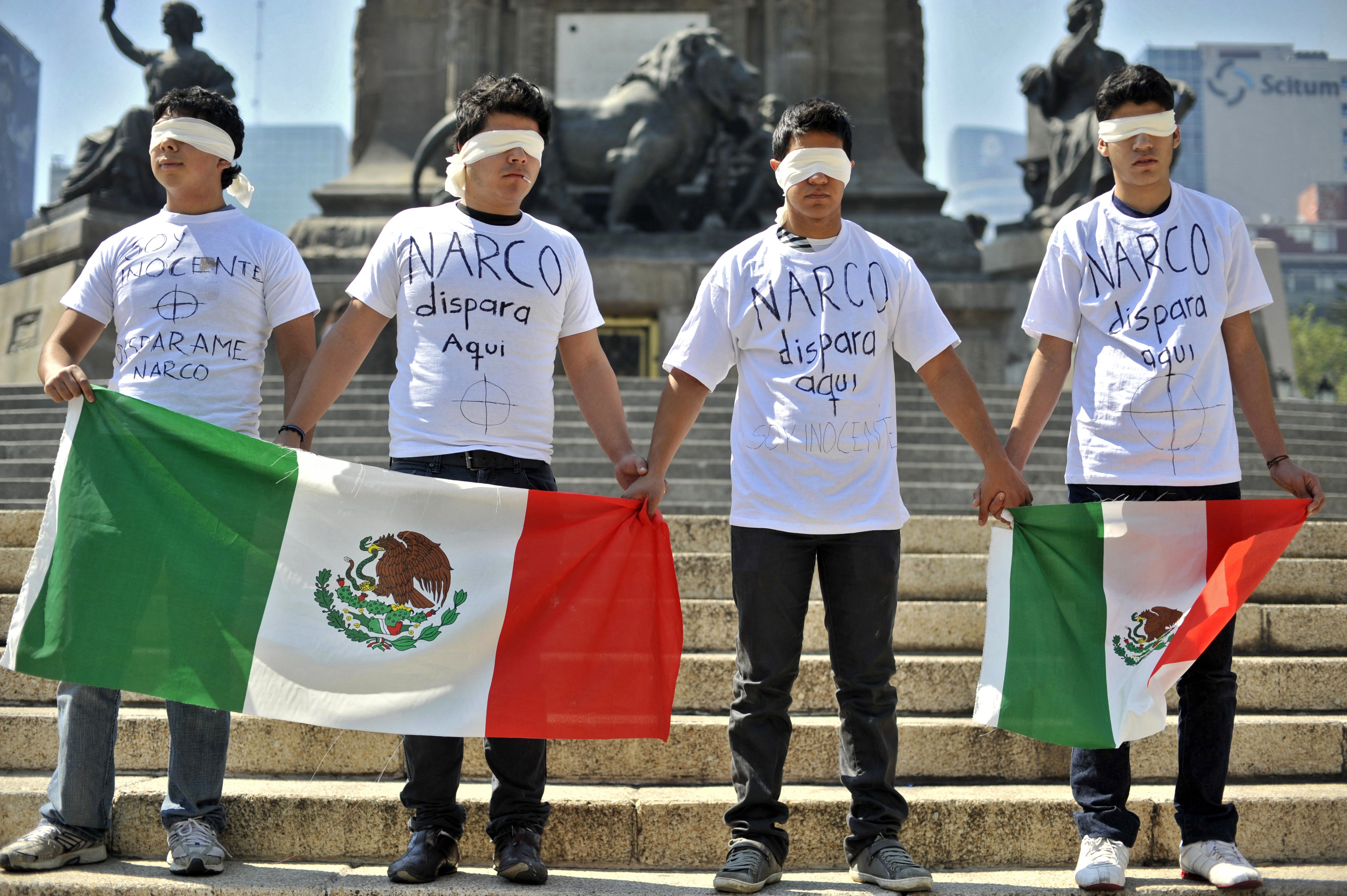 Members of a social organisation hold Mexican national flags as they protest against Ciudad Juárez’s drug gangs' violence