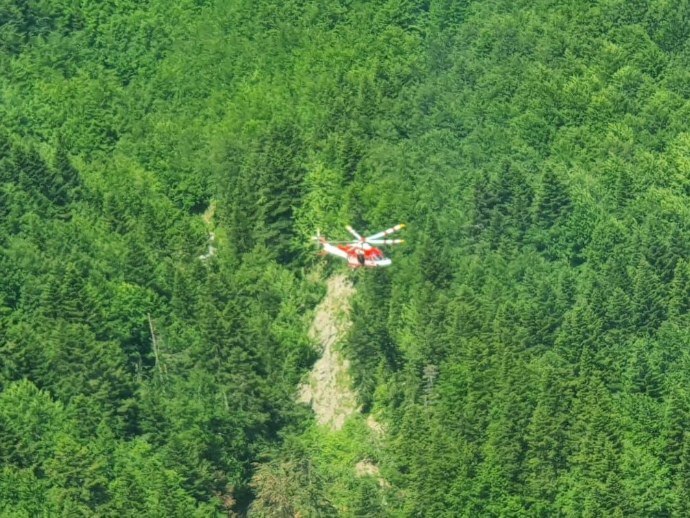 An Alpine Rescue helicopter flies over the crash site near Pievepelago, Italy