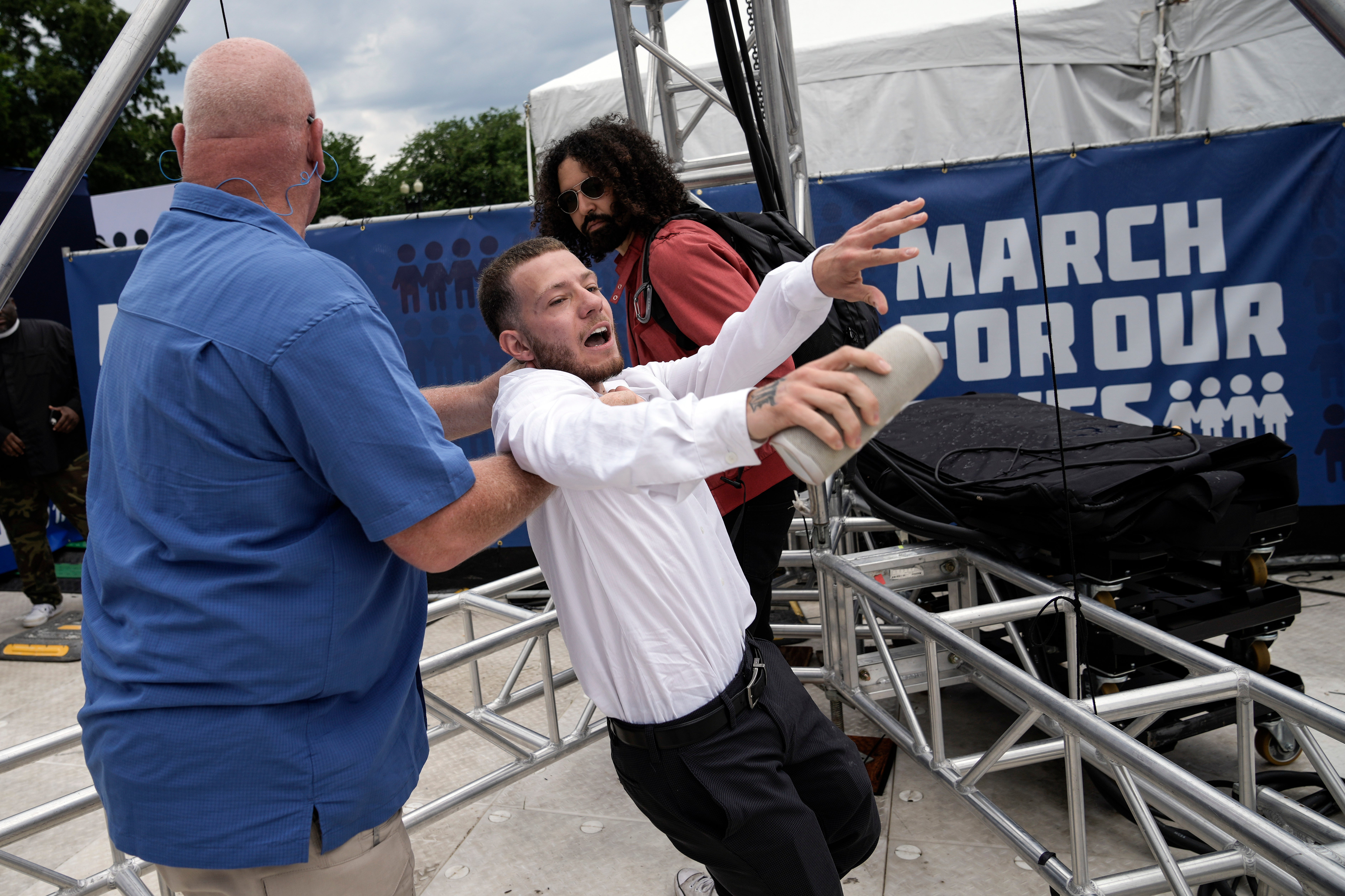 The man is pulled away by Park Police officers