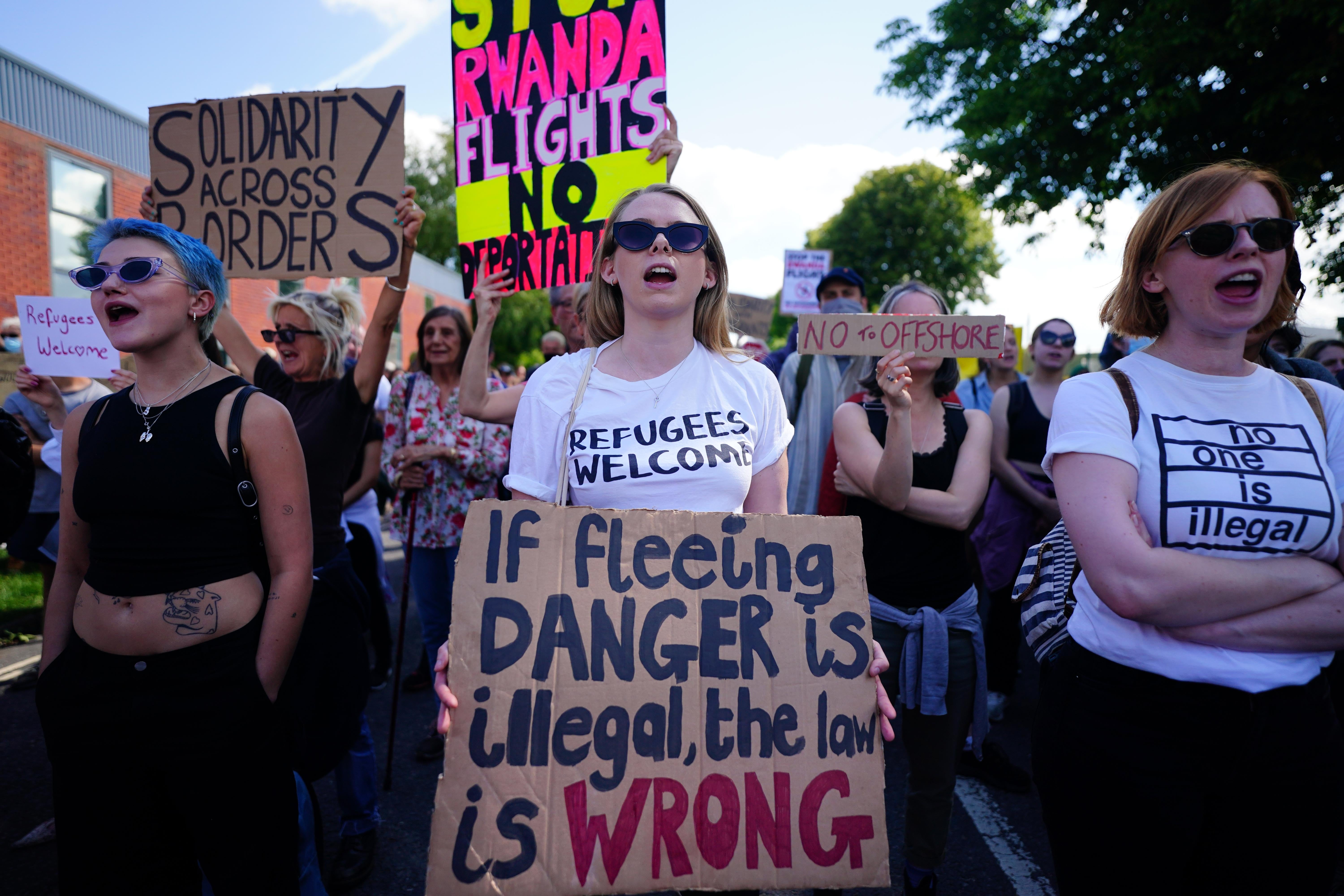 Demonstrators at a removal centre near Gatwick protest against plans to send migrants to Rwanda (PA)