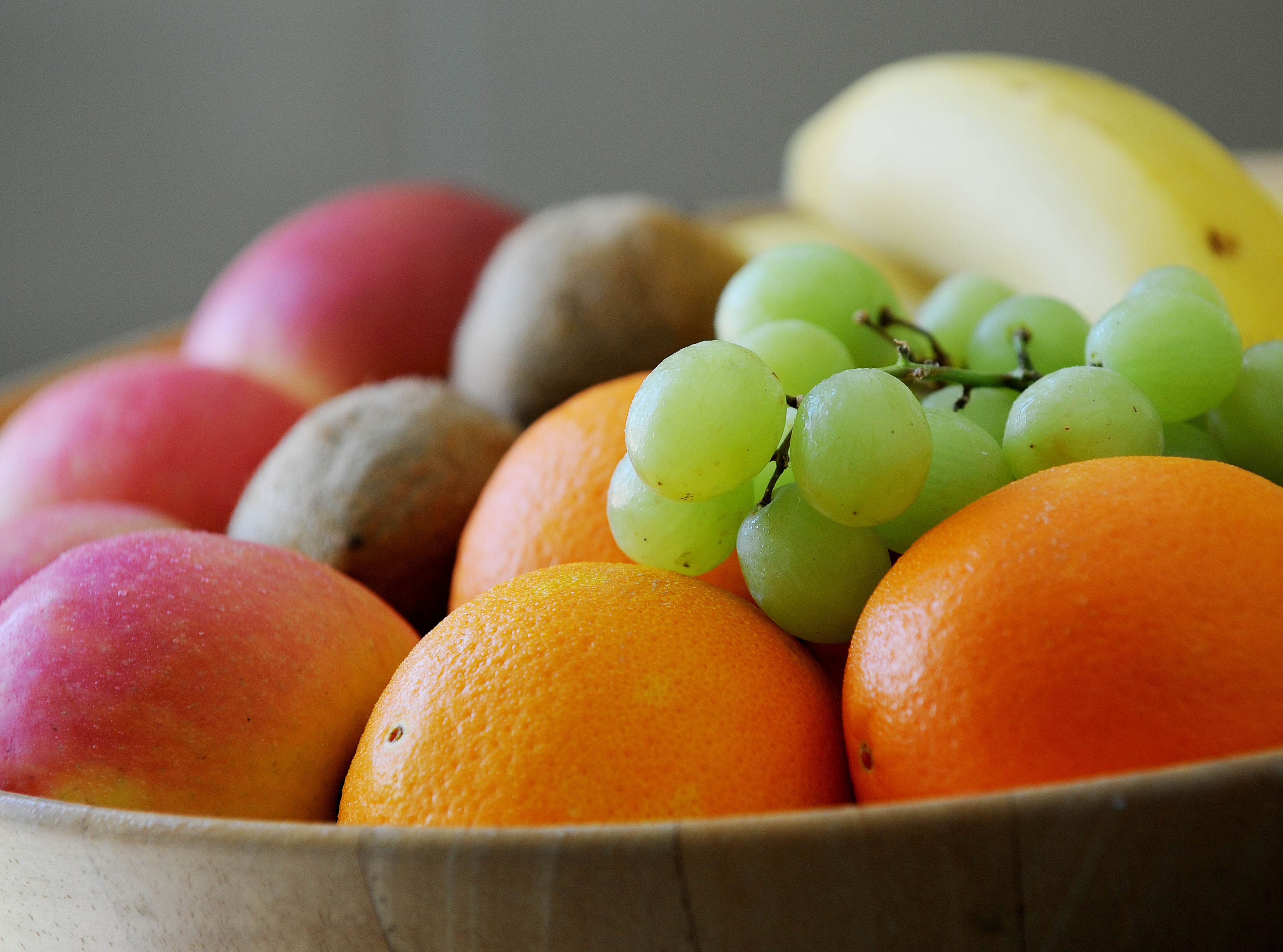 Grapes, Oranges, apples bananas and Kiwifruit in a fruit bowl