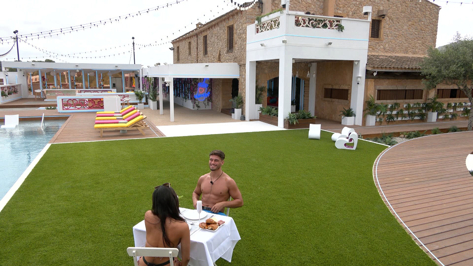 Jacques and Paige date while the girls look on from the balcony