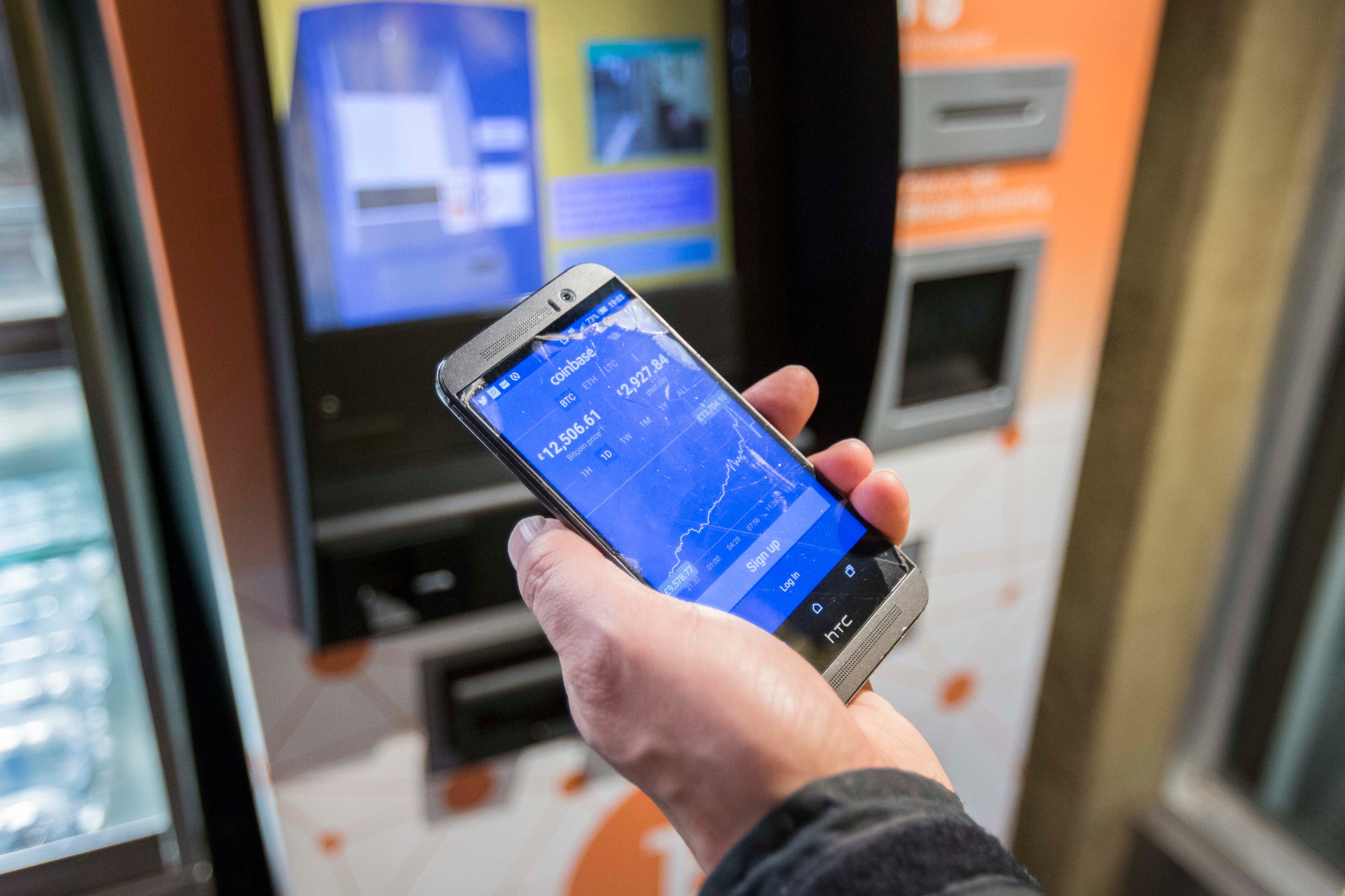 A customer uses a Bitcoin machine in Old Street underground station in London (Rick Findler/PA)