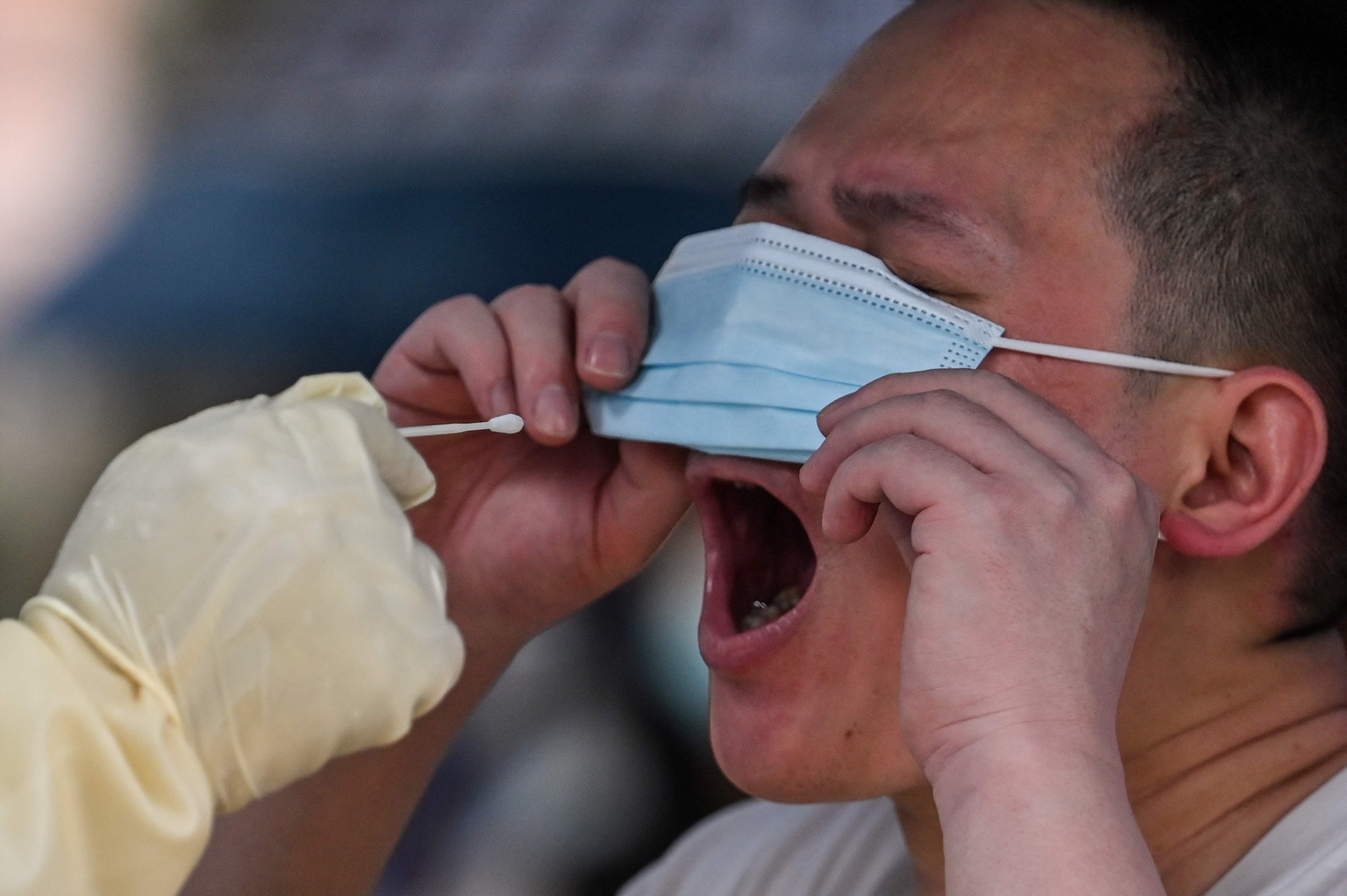 A health worker takes a swab sample from a man to test for Covid