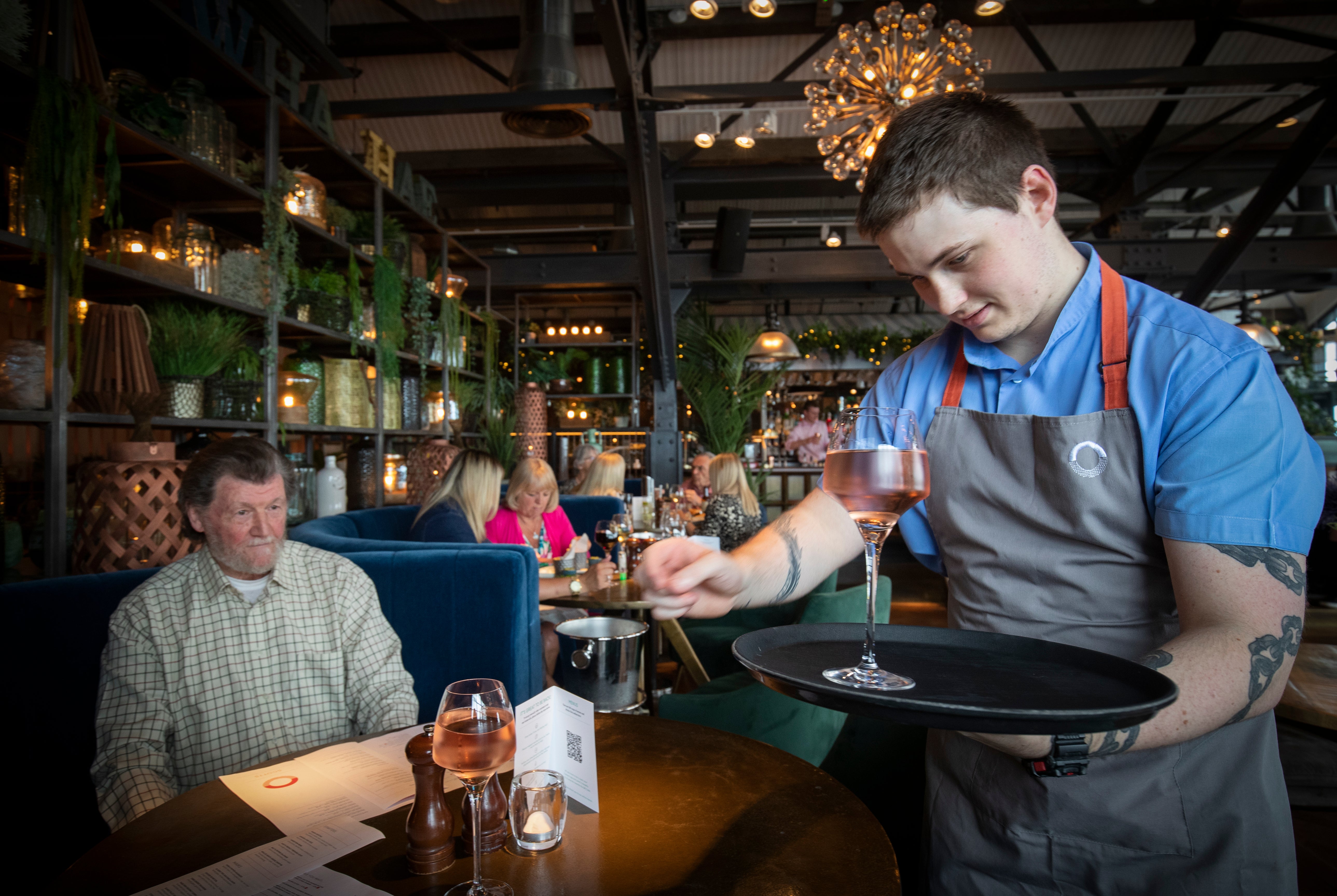 Barman Matthew Williams serves drinks at Scotts in South Queensferry. Hospitality vacancies have hit record levels as bosses have warned staff shortages are impact trade (Jane Barlow/PA)