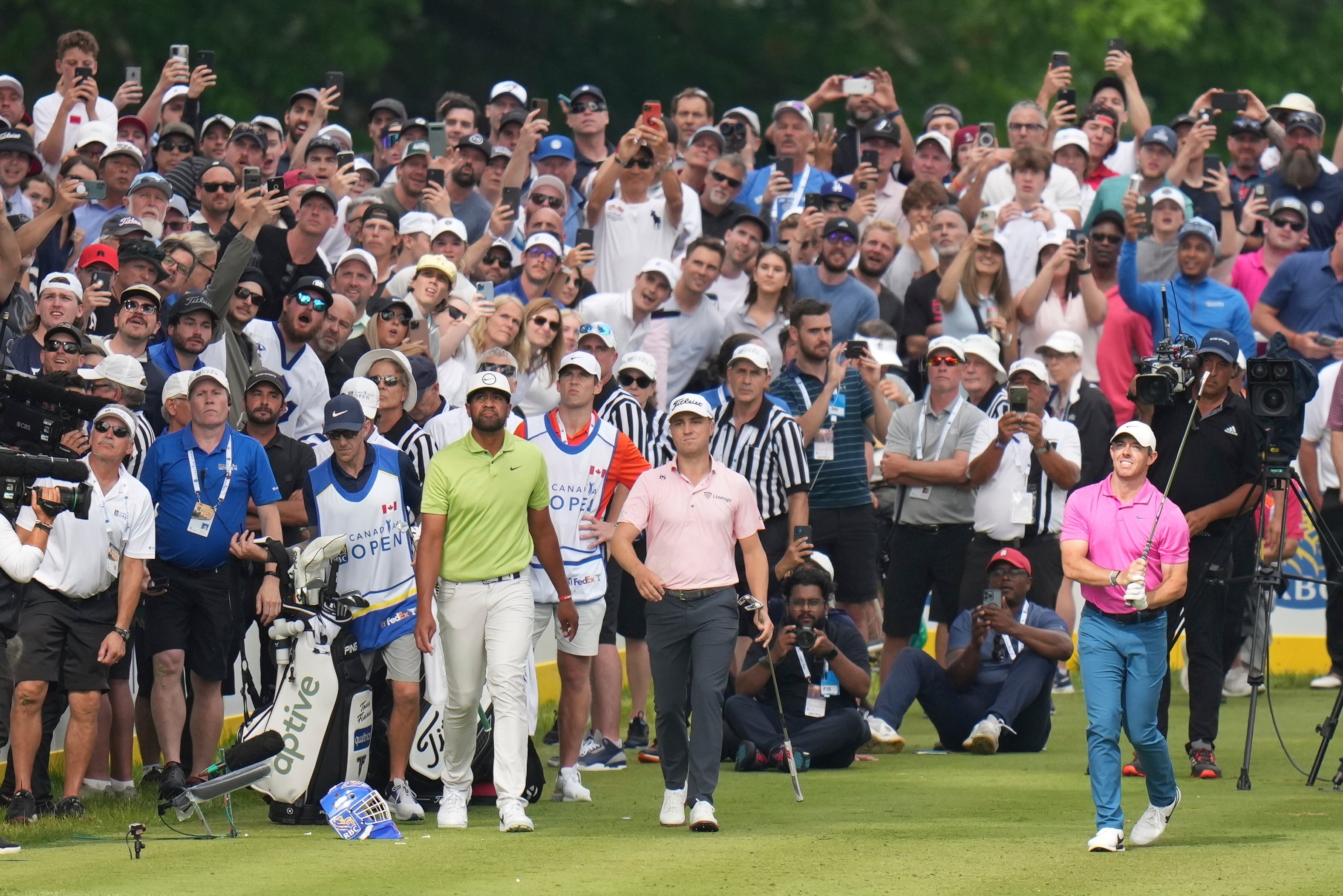 Rory McIlroy, front right, tees off on the 16th hole as Justin Thomas, centre, and Tony Finau look on during the final round of the Canadian Open (Nathan Denette/The Canadian Press via AP)