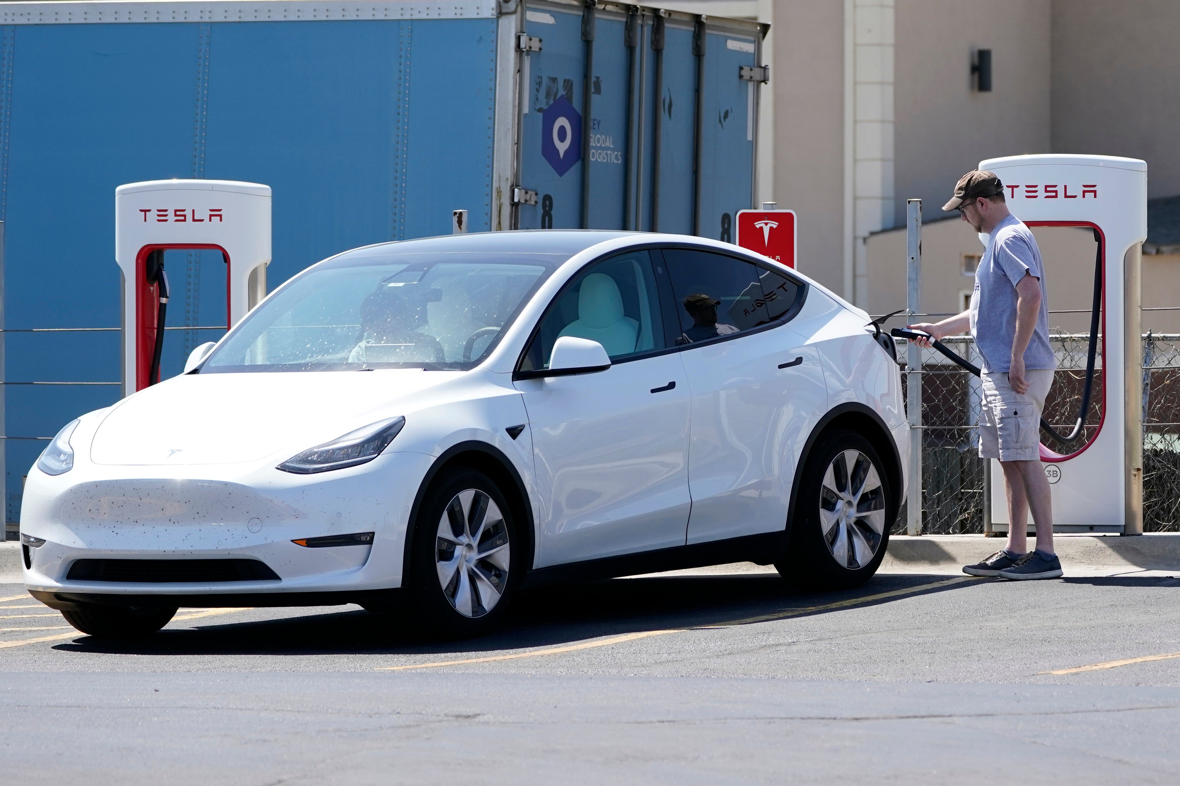 A Tesla being charged by its driver