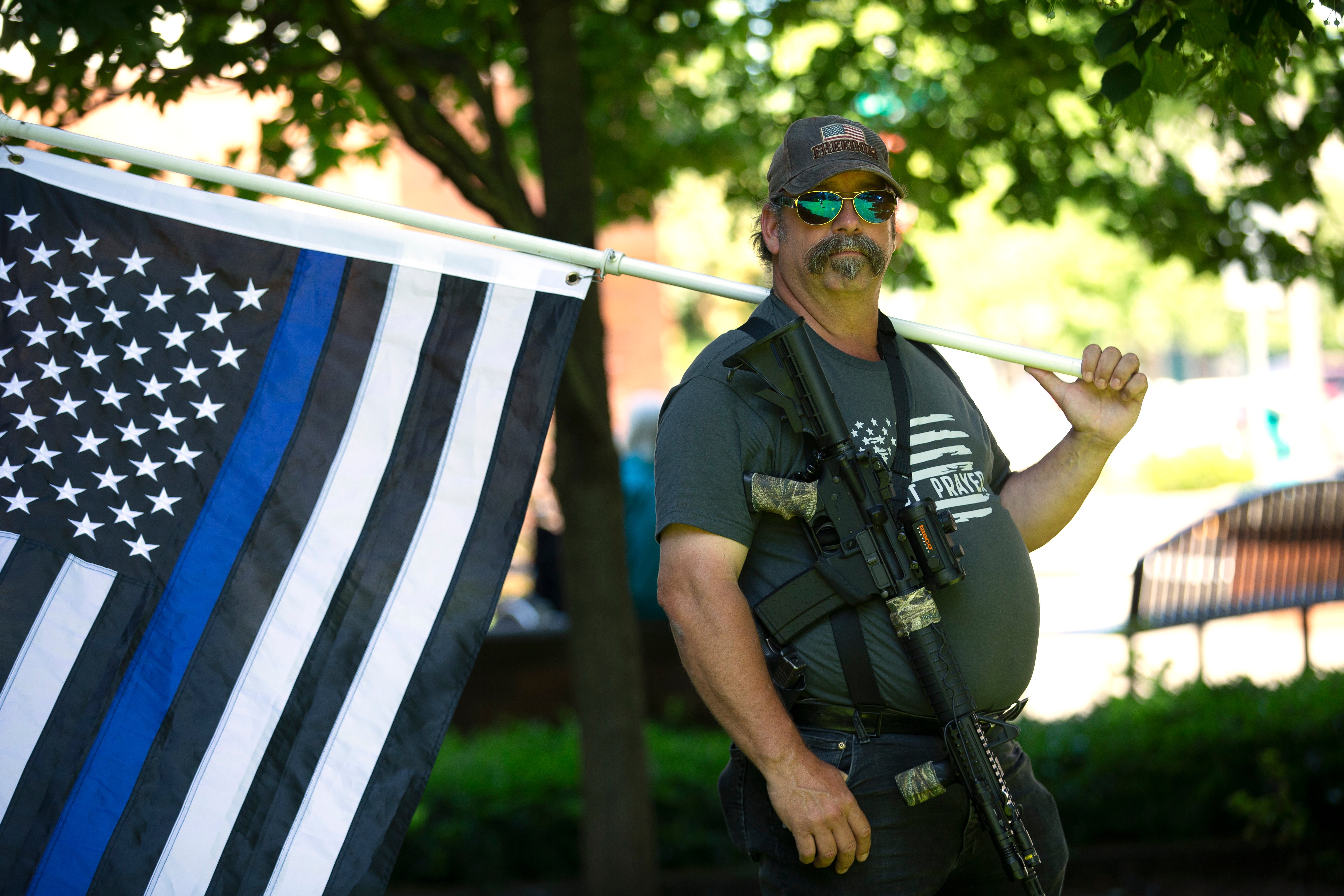 Josh Bradley holds a thin blue line flag during a Patriot Prayer and Peoples Rights Washington rally against the Washington state mask mandate outside the Clark County Sheriffs Office on June 26, 2020 in Vancouver, Washington