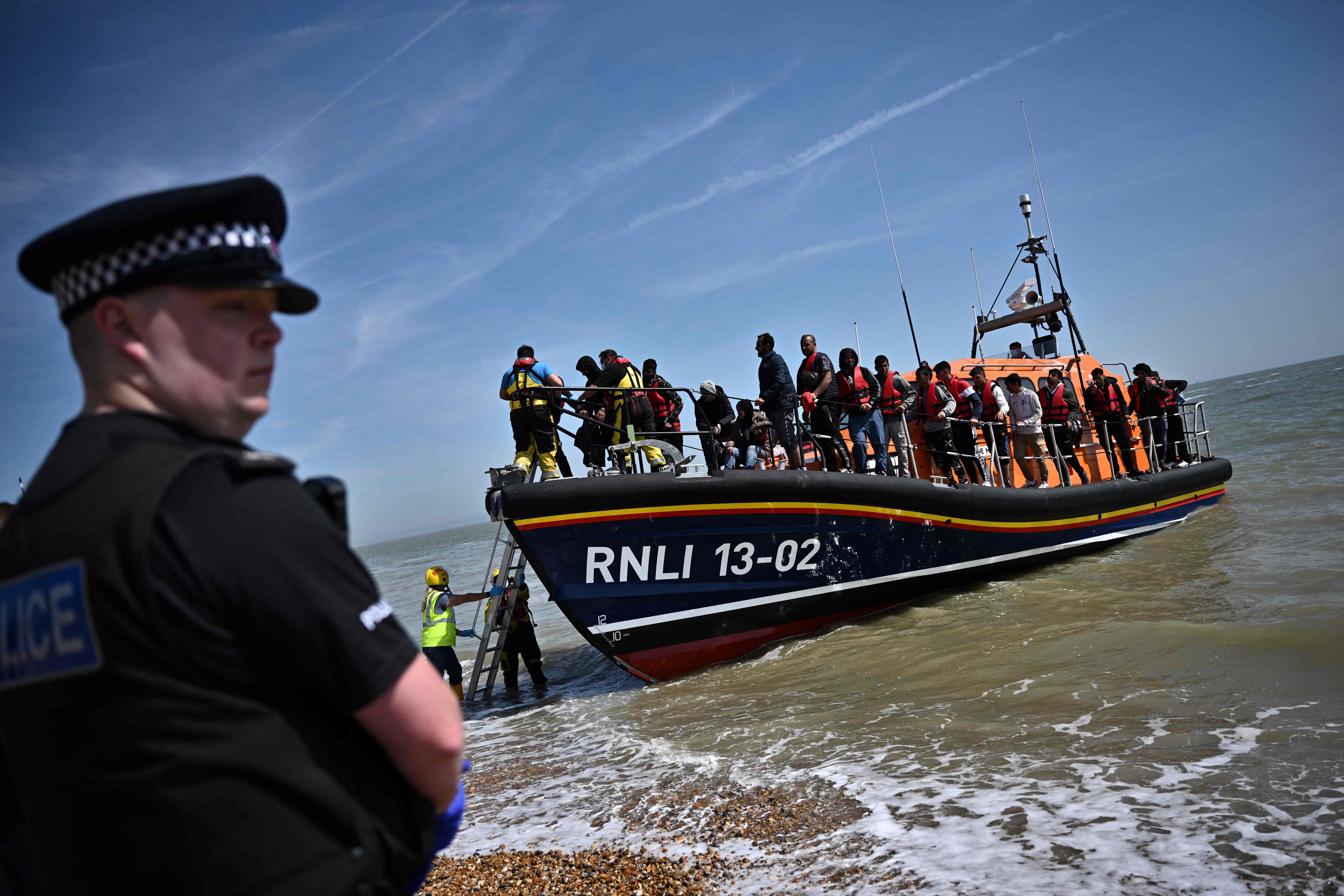 Royal National Lifeboat Institution’s (RNLI) members of staff help migrants to disembark from one of their lifeboats after they were picked up at sea while attempting to cross the English Channel.