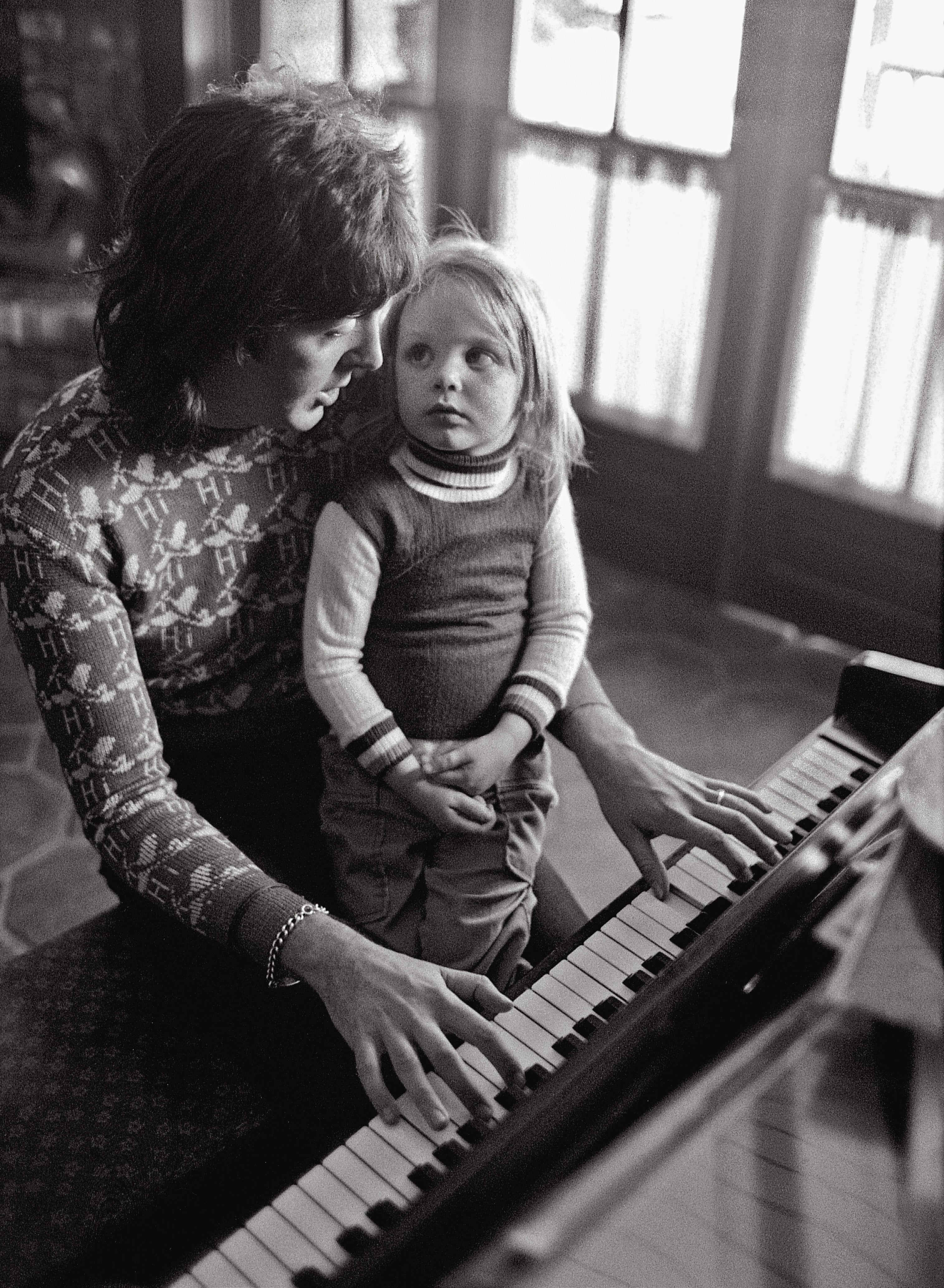 Stella, 3, looks up lovingly as her father plays and sings for her during their stay in Los Angeles, March 1975