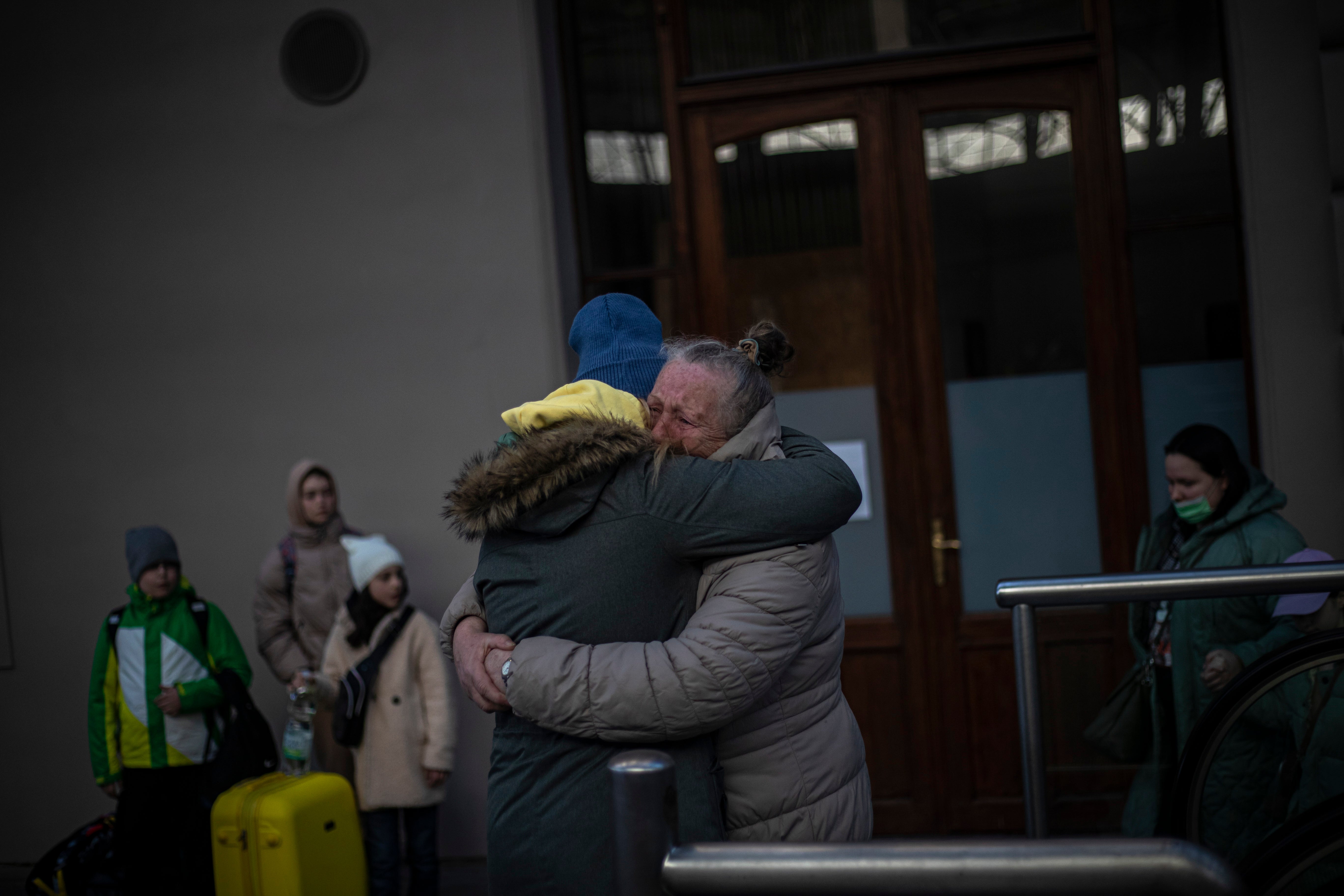 Two women embrace as people fleeing Ukraine arrive at the main railway station in Prague