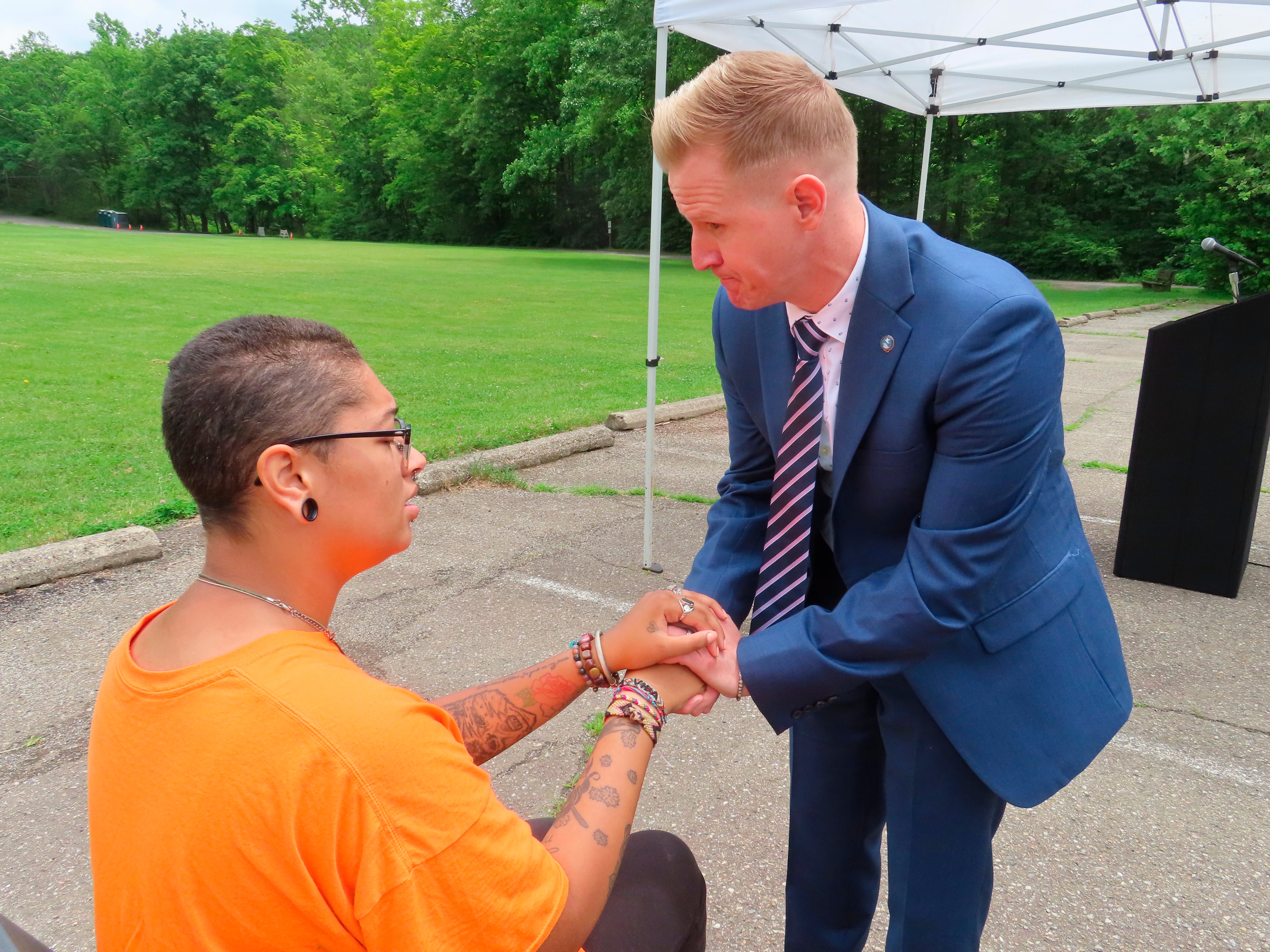 Shawn LaTourette, New Jersey’s environmental protection commissioner, right, holds the hand of Angel Stefancik.