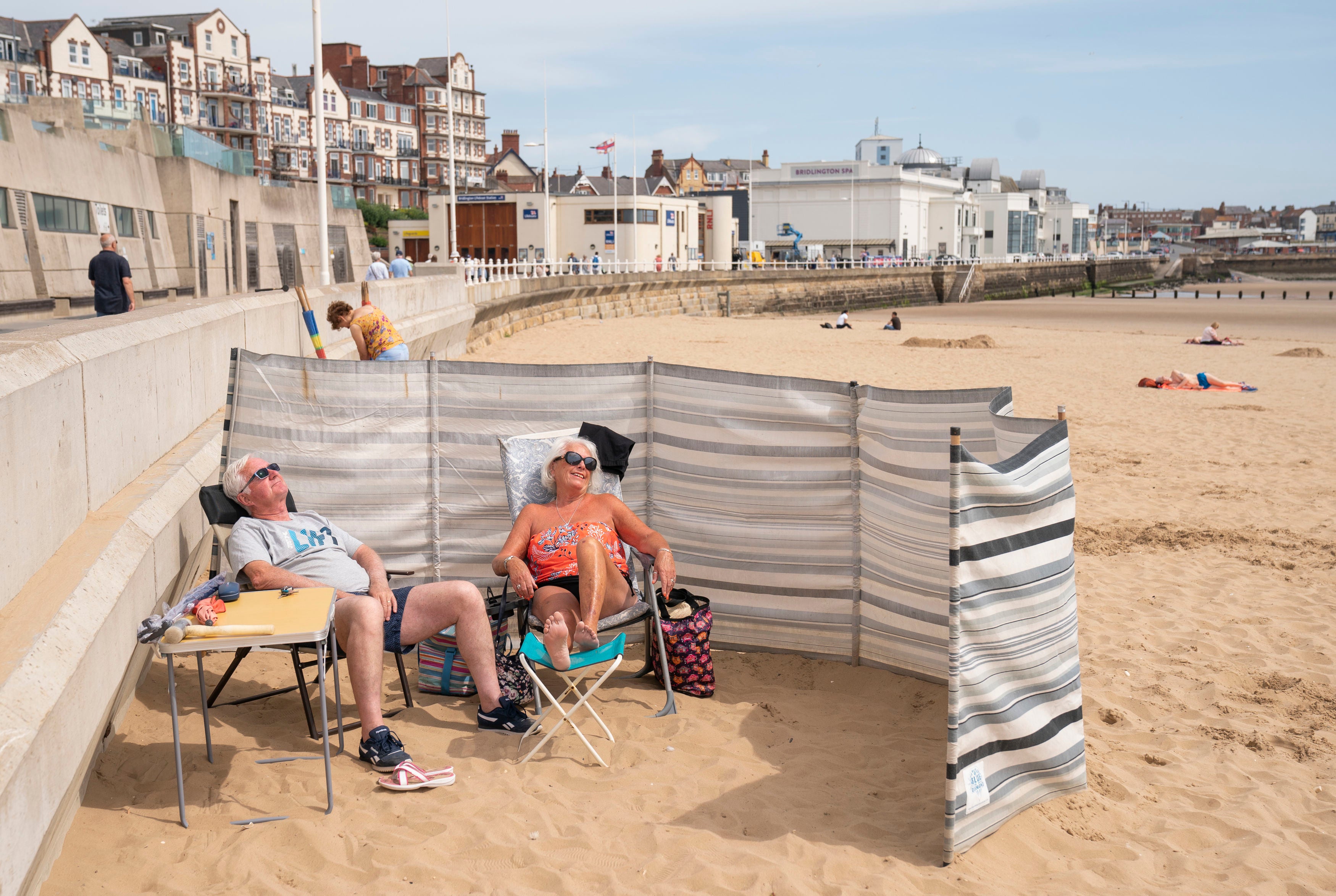 People sunbathe as they enjoy the hot weather on Bridlington beach on the Yorkshire coast