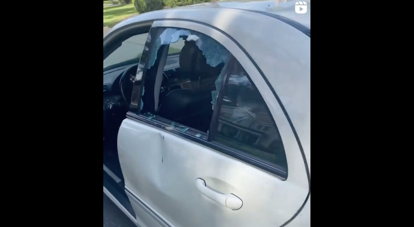 The back window of the teen’s car can be seen smashed from a rock allegedly being thrown into the backseat