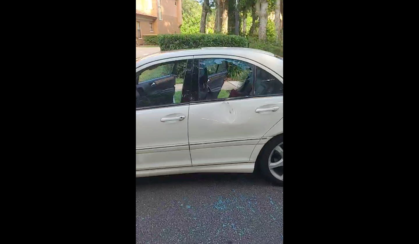 The father of the 16-year-old, CJ Jones, surveys the damage done to the white Mercedes after a rock was allegedly hurled at his son while he was in the driver’s seat