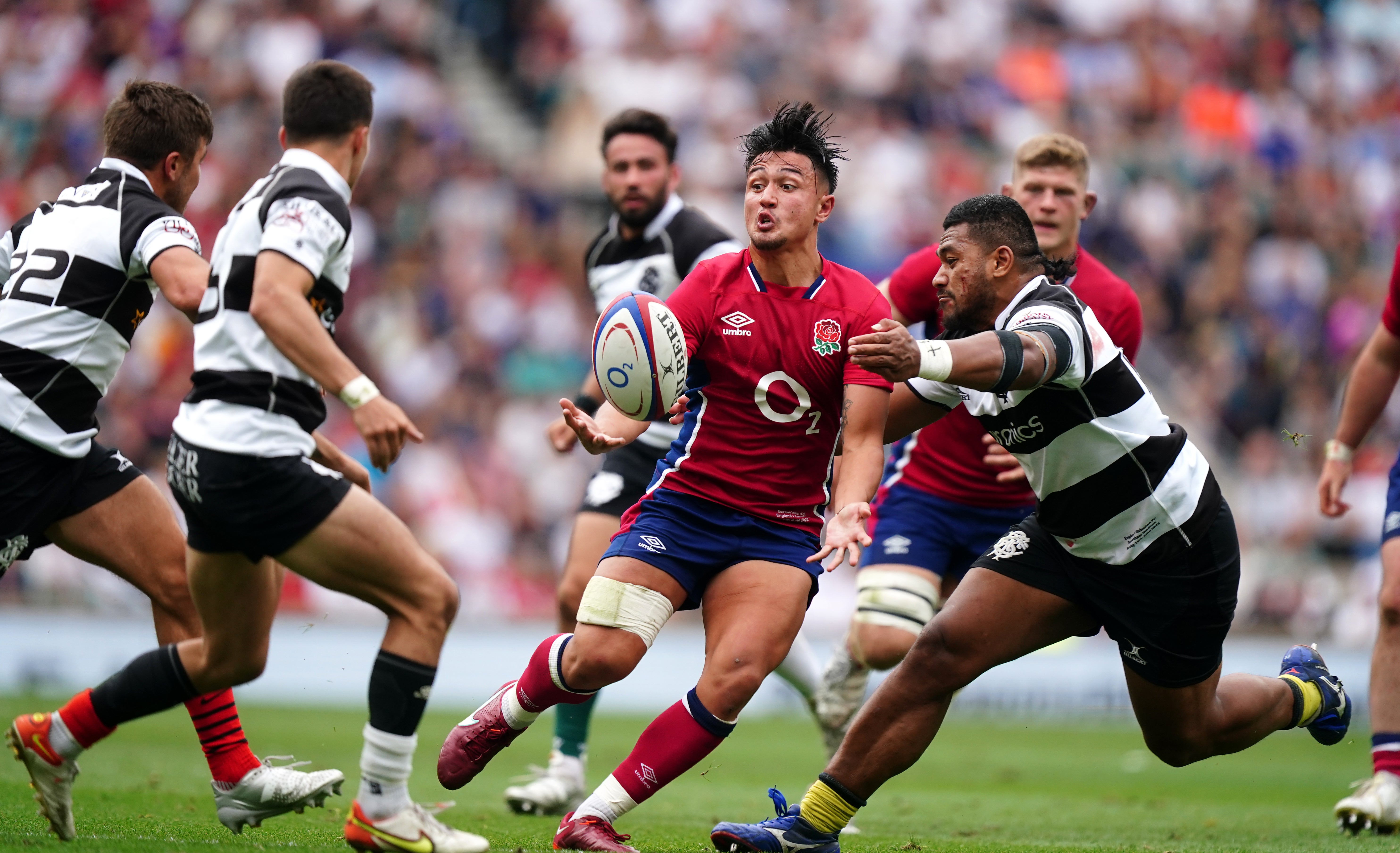 England’s Marcus Smith, centre, is tackled by Barbarians’ Sipili Falatea (Mike Egerton/PA)