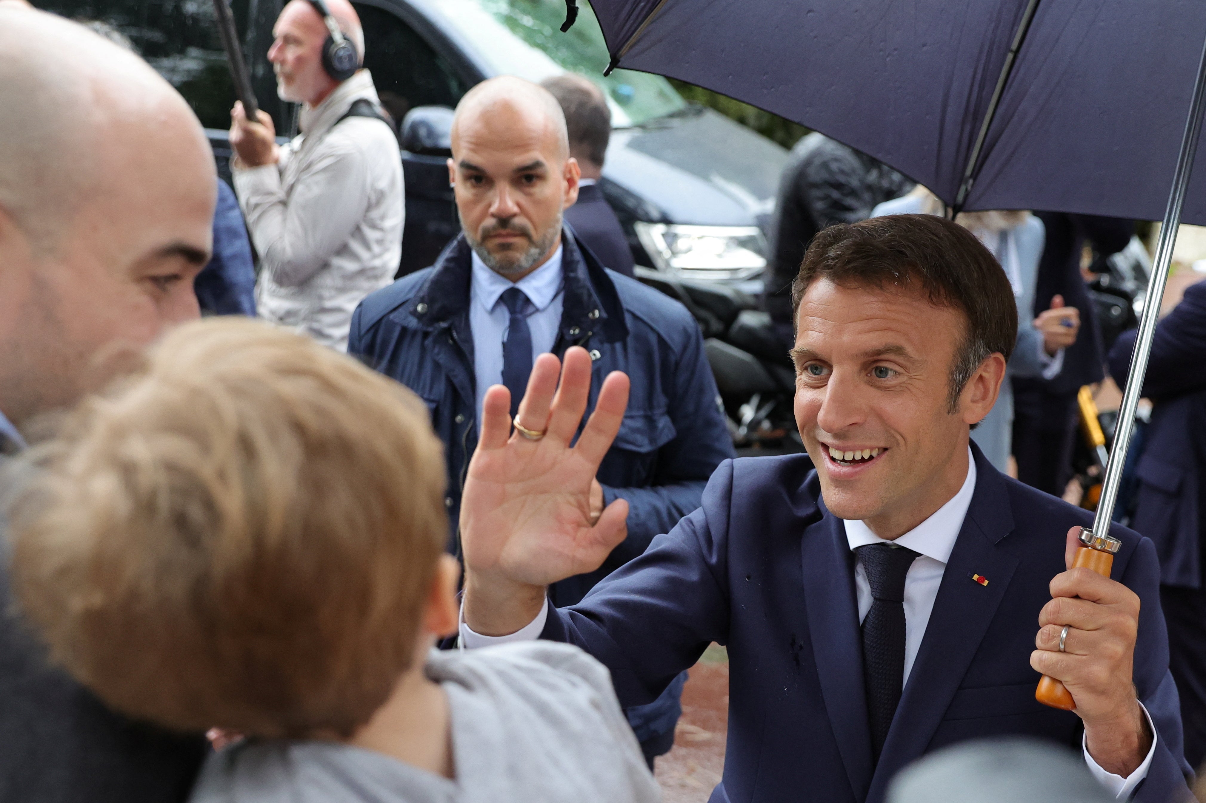 French President Emmanuel Macron greets supporters as he leaves after voting in the second round of French parliamentary election