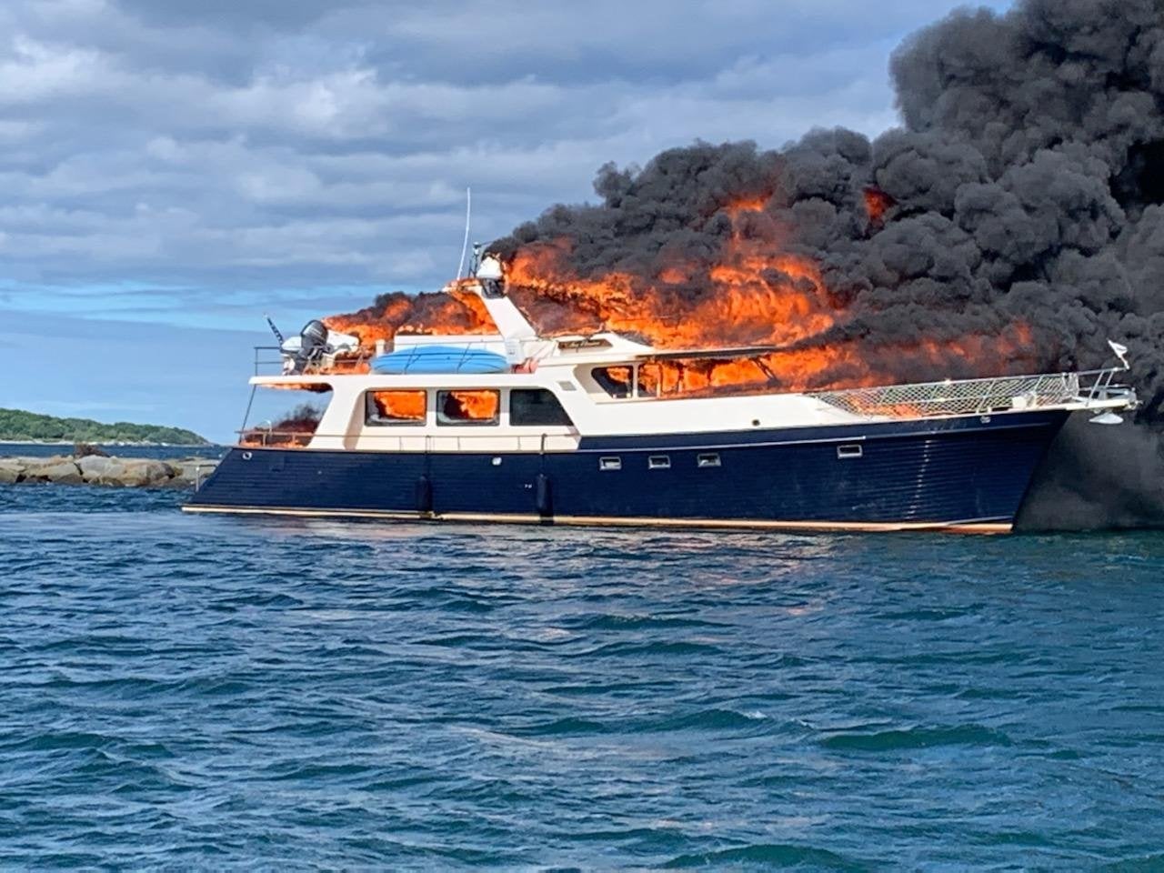 Passengers onboard the 72-foot yacht noticed black smoke sneaking up from below deck on Saturday afternoon and within minutes they were engulfed in flame and jumping overboard with their two dogs